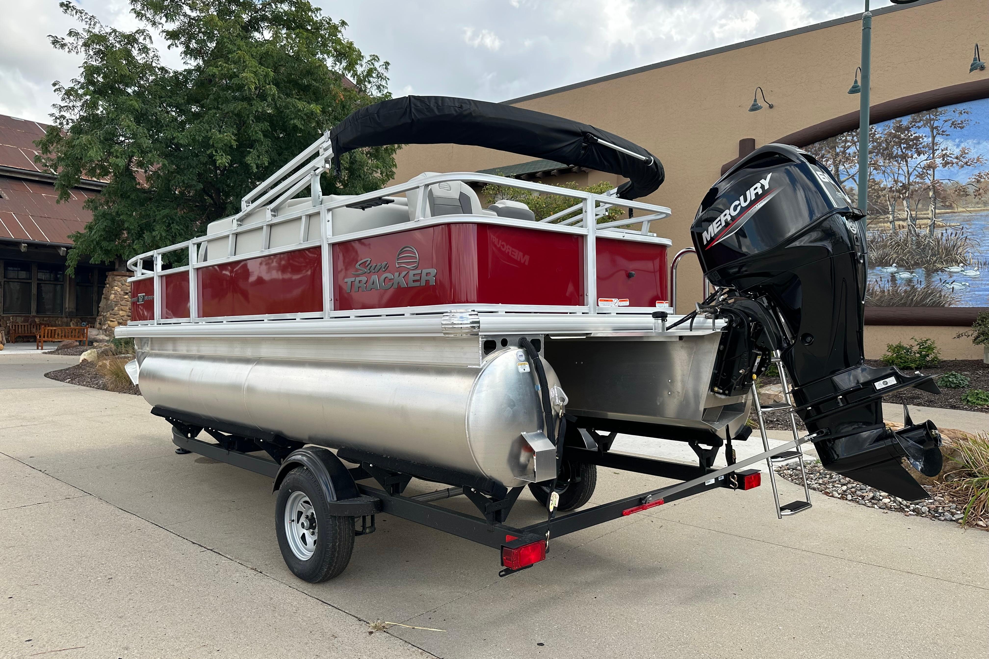 2026 Sun Tracker Bass Buggy 18 DLX pontoon boat with Mercury outboard motor on trailer.