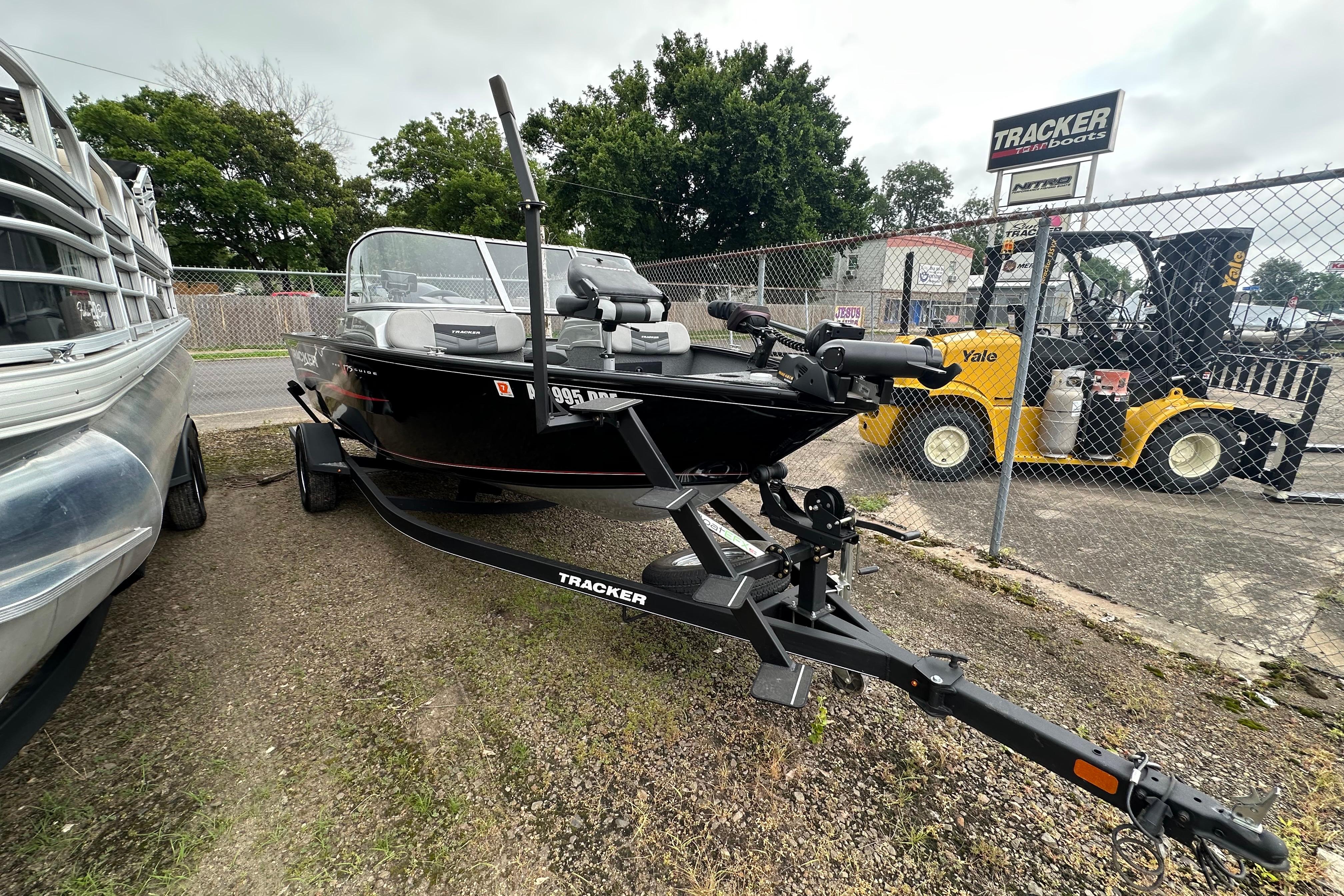 2018 Tracker Pro Guide V-175 Combo boat on trailer, parked outdoors near a fence.