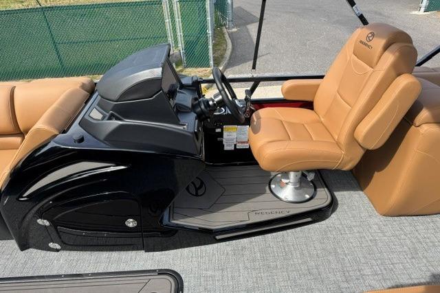 Luxurious 2026 Regency 230 DL boat interior with tan captain's chair and sleek black console.
