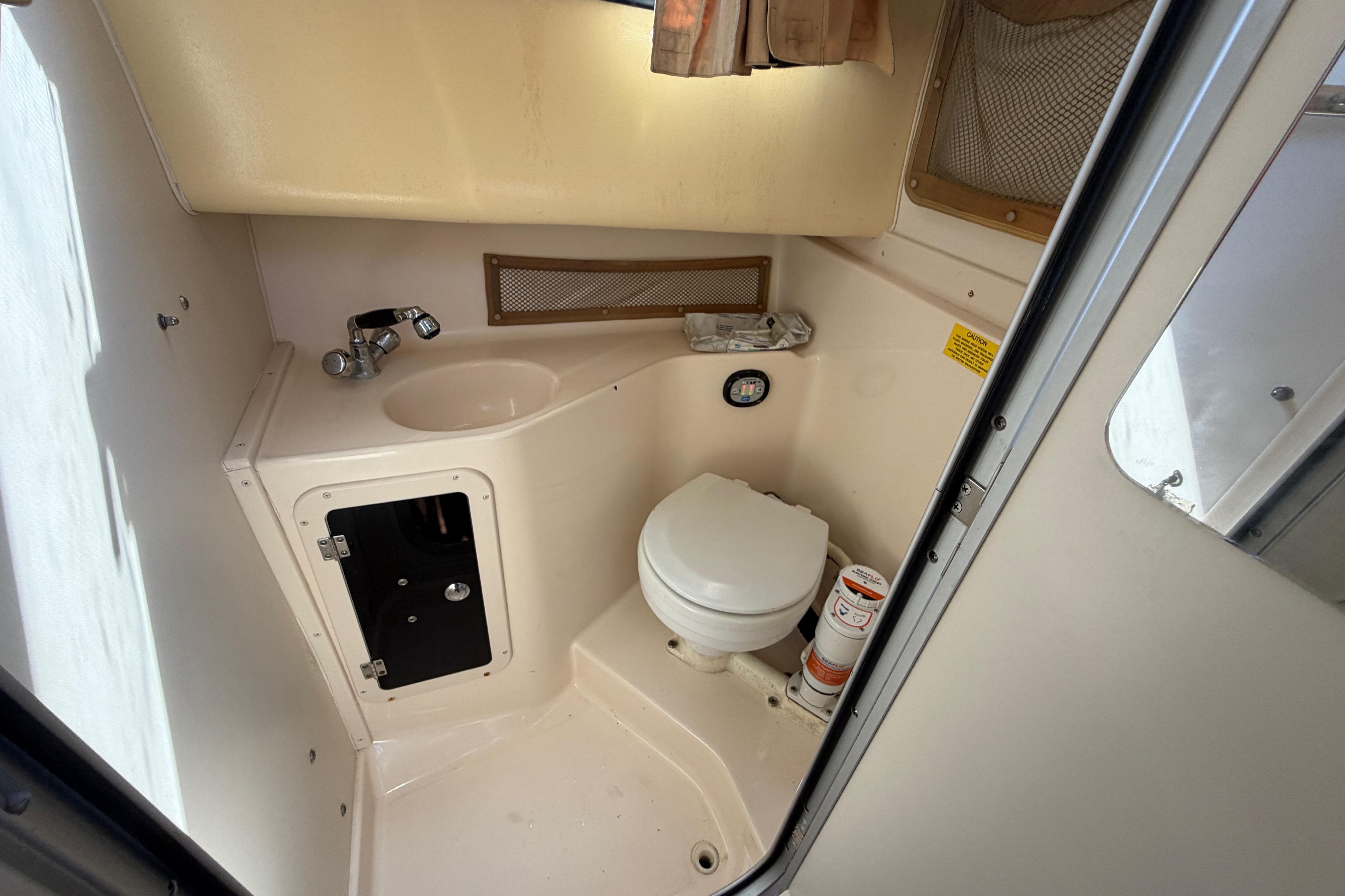 2006 Grady-White Sailfish 282 boat bathroom with sink, toilet, and storage.