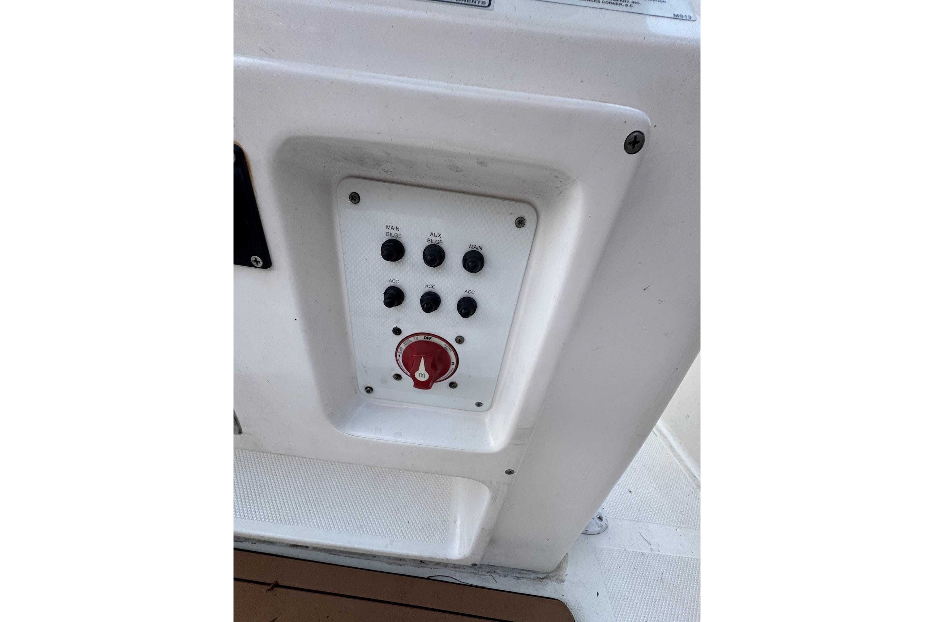 Control panel on a 2013 Sea Fox 246 Commander boat, featuring switches and a red dial.