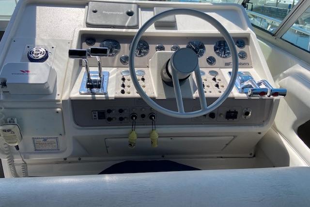Control panel of a 1994 Cruisers Yachts 3675 Esprit boat, featuring steering wheel and gauges.