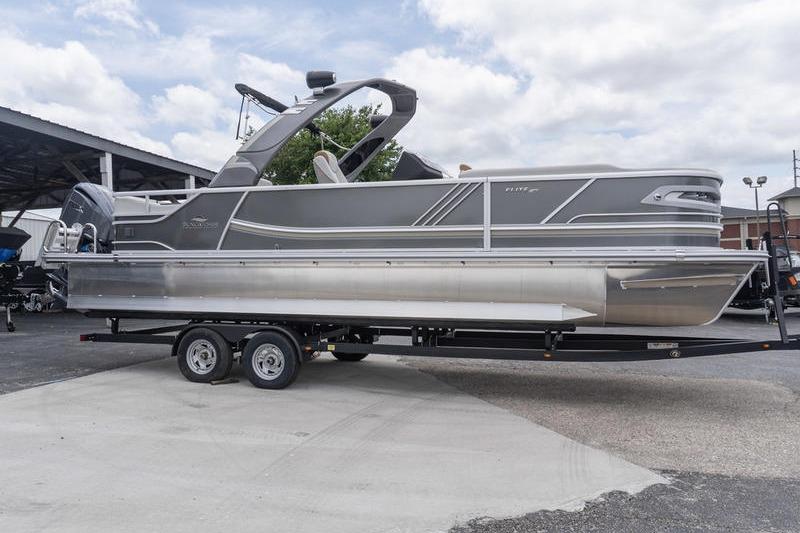 2026 SunCatcher Elite 326 SS pontoon boat on trailer, parked outdoors.