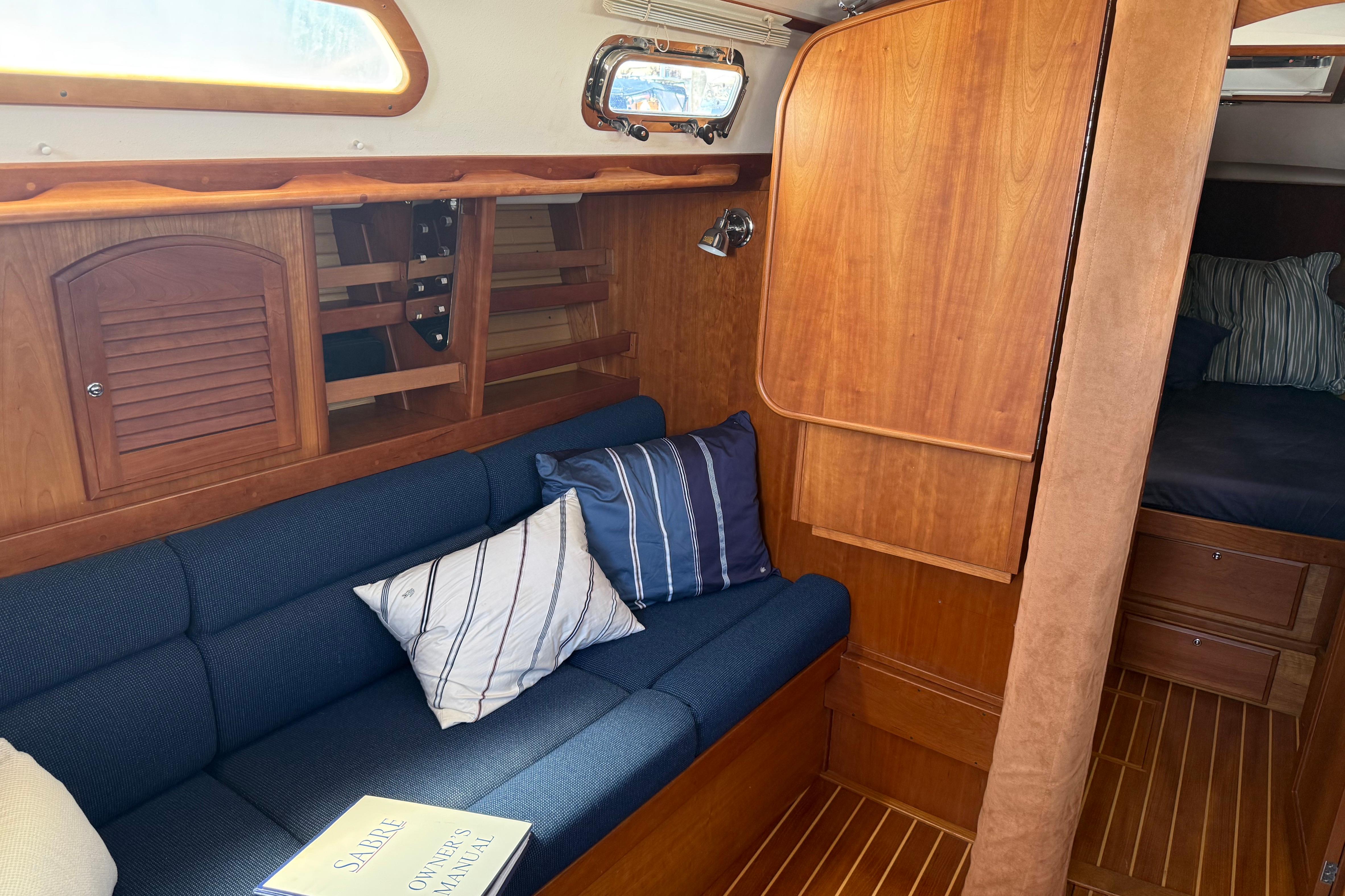 Interior of 2004 Sabre 386 sailboat with cozy seating and wooden cabinetry.