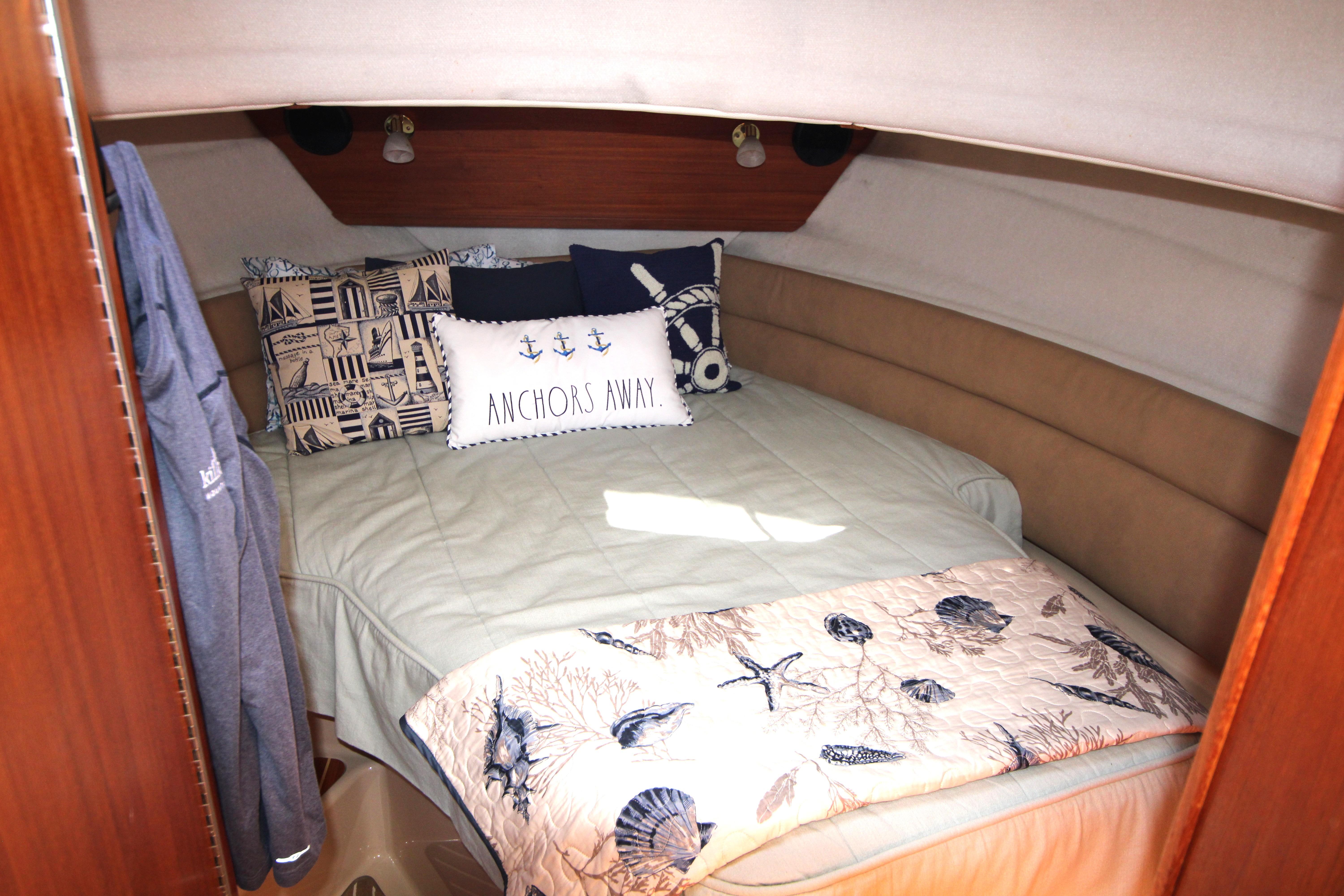 Cozy cabin interior of 2013 Ranger Tugs R-31 CB with nautical-themed bedding.