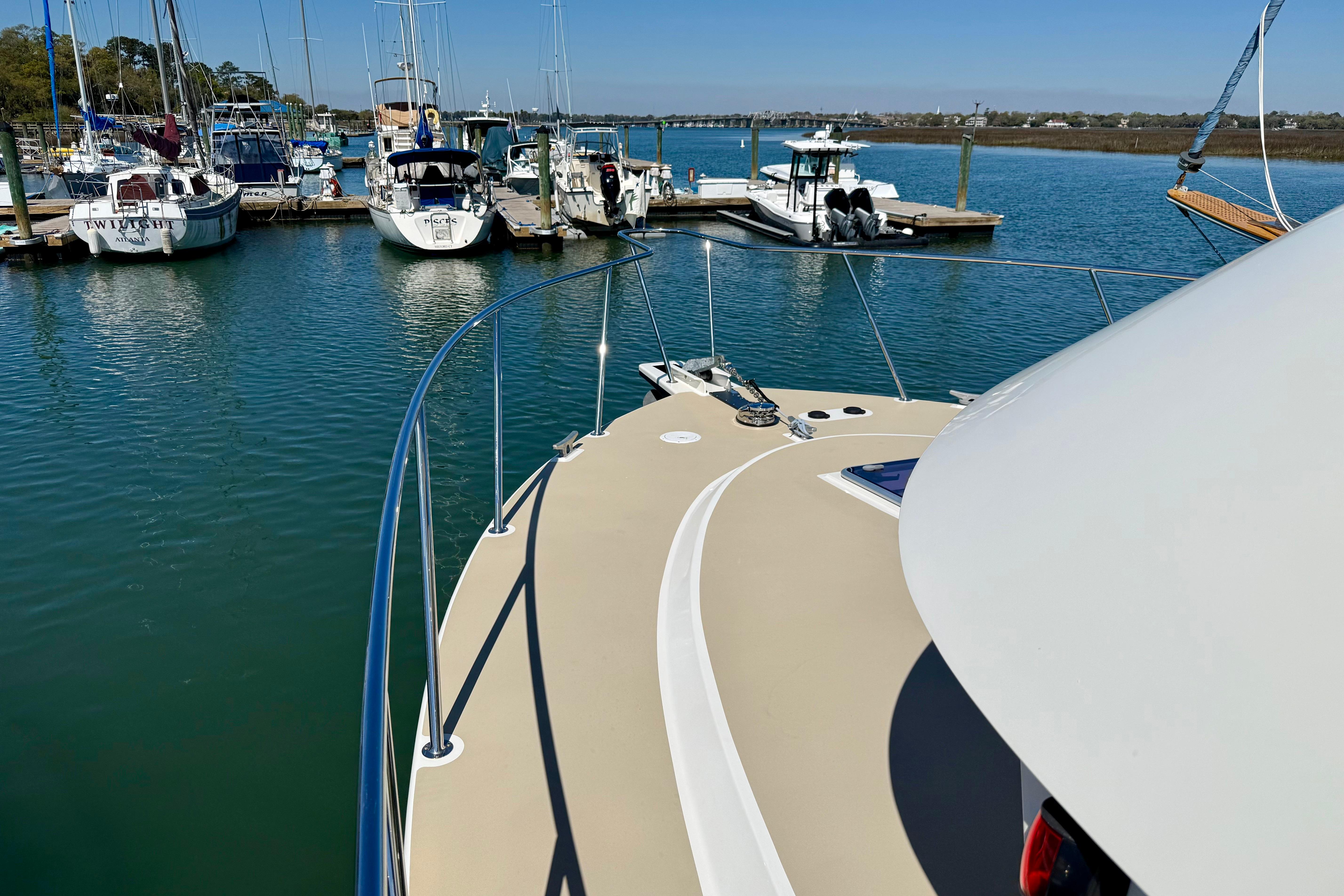 2015 Coastal Craft 45 yacht docked in a serene marina with other boats.