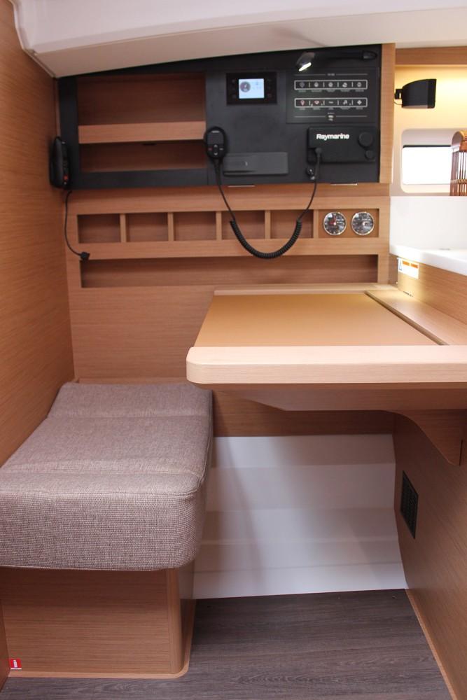 Interior of 2025 Jeanneau Sun Odyssey 440, featuring navigation station and seating area.