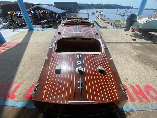 Classic 2000 Grand Craft Runabout with wooden deck, docked by the waterfront.