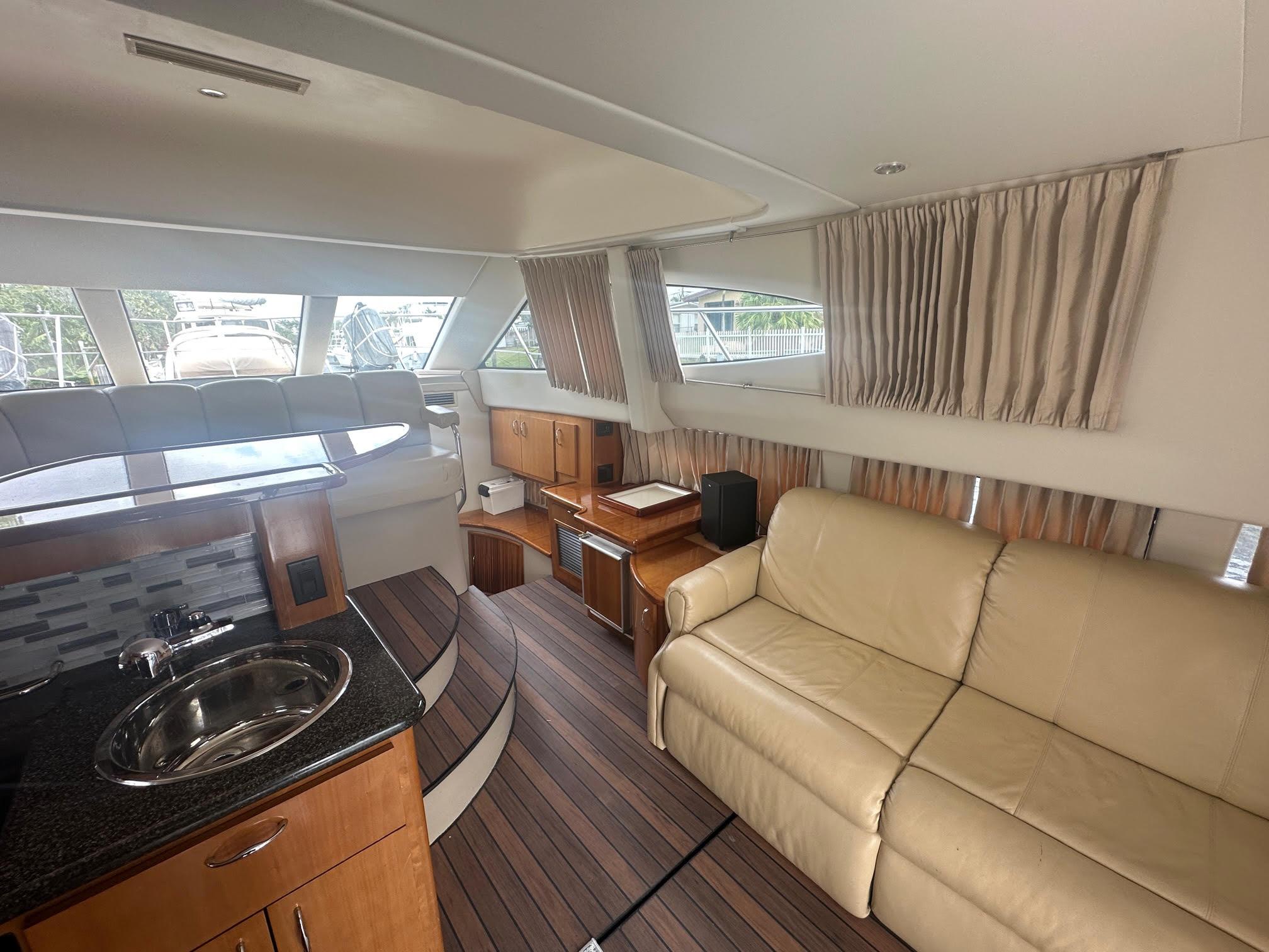 Interior of 2005 Carver 36 Super Sport yacht with beige sofa and kitchenette.