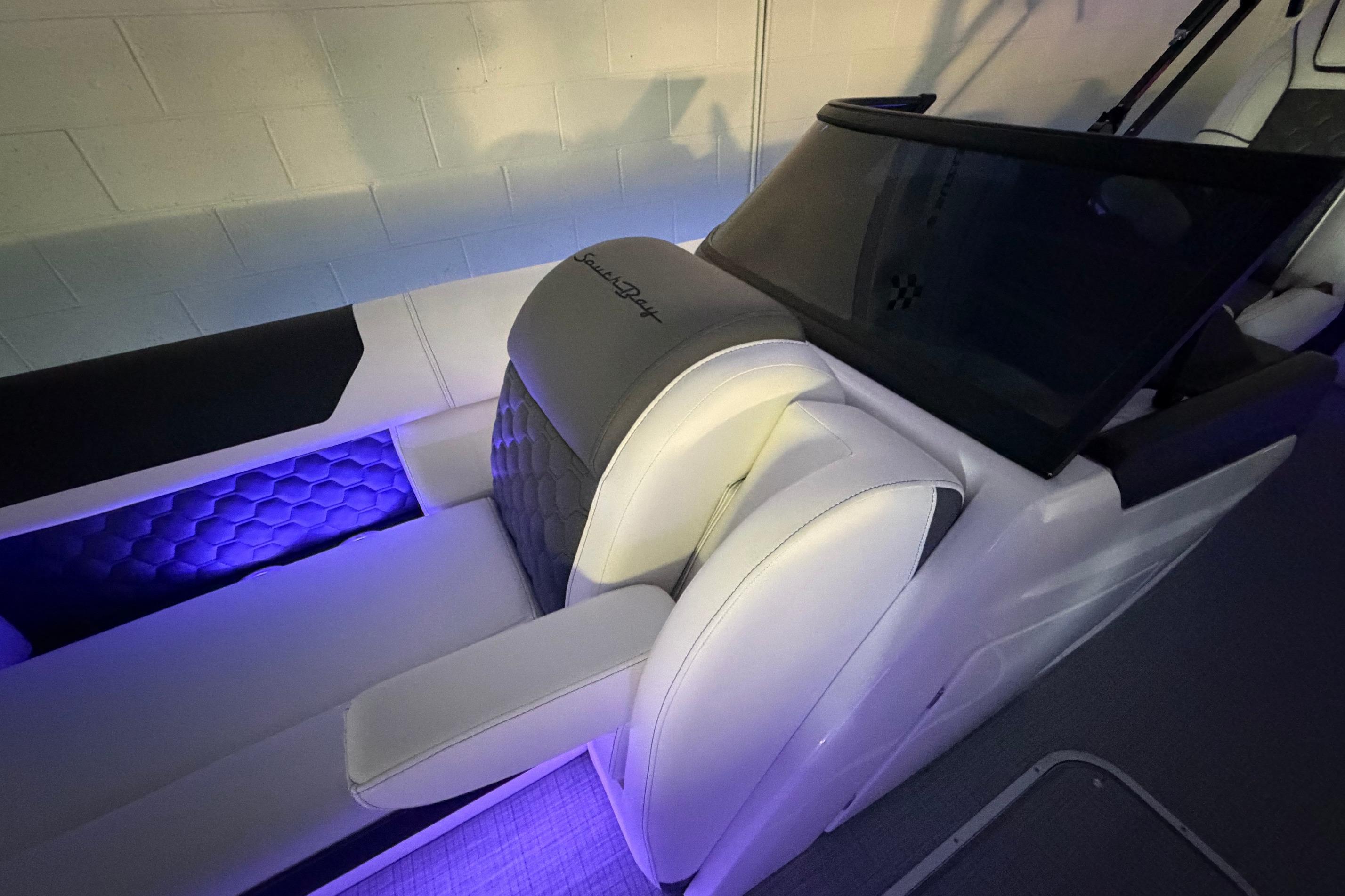 Luxurious interior of 2026 South Bay 525SB2 boat with ambient lighting and plush seating.