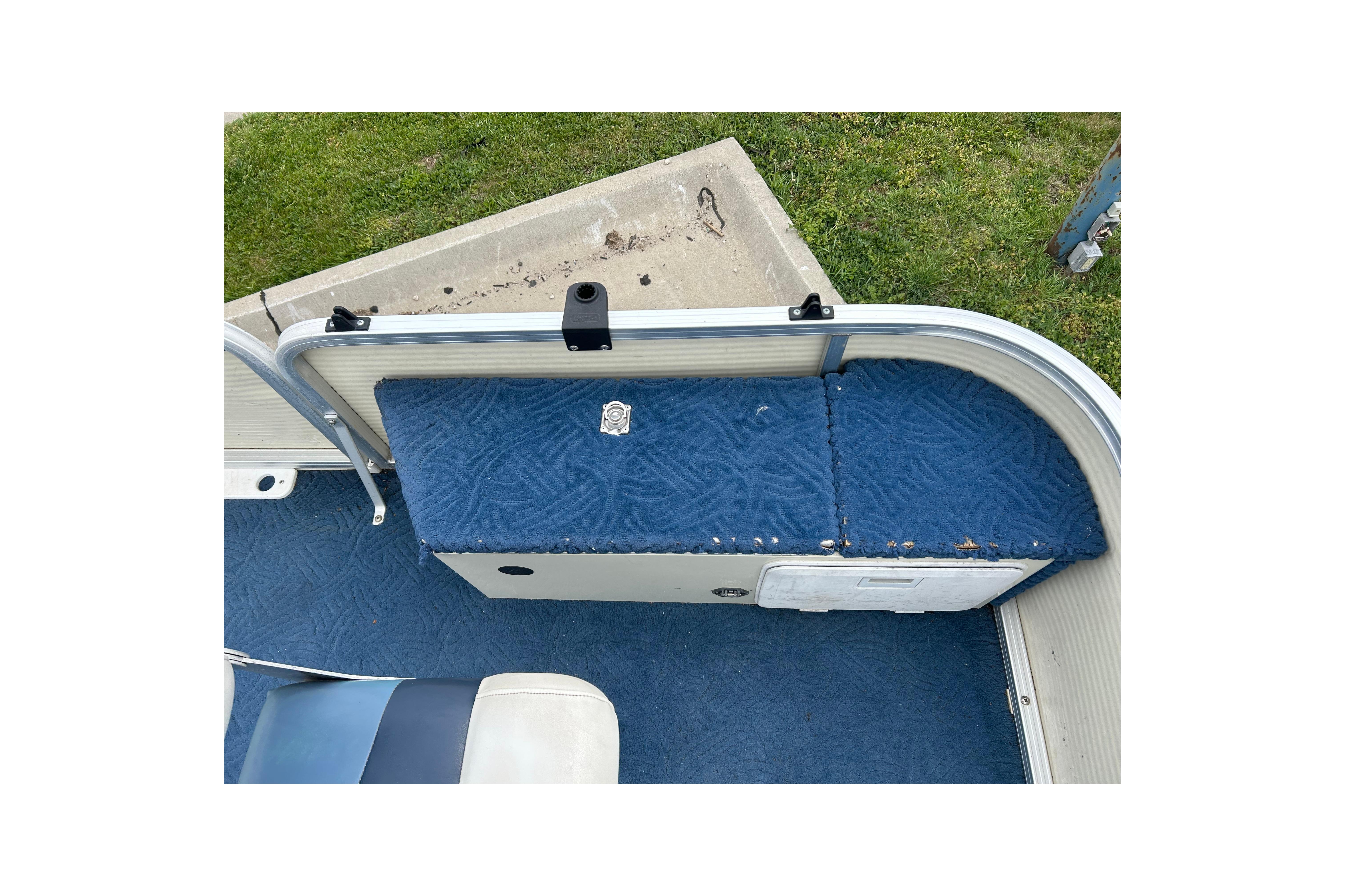 2002 Lowe Trinidad 200 boat interior with blue cushioned seating and storage compartment.
