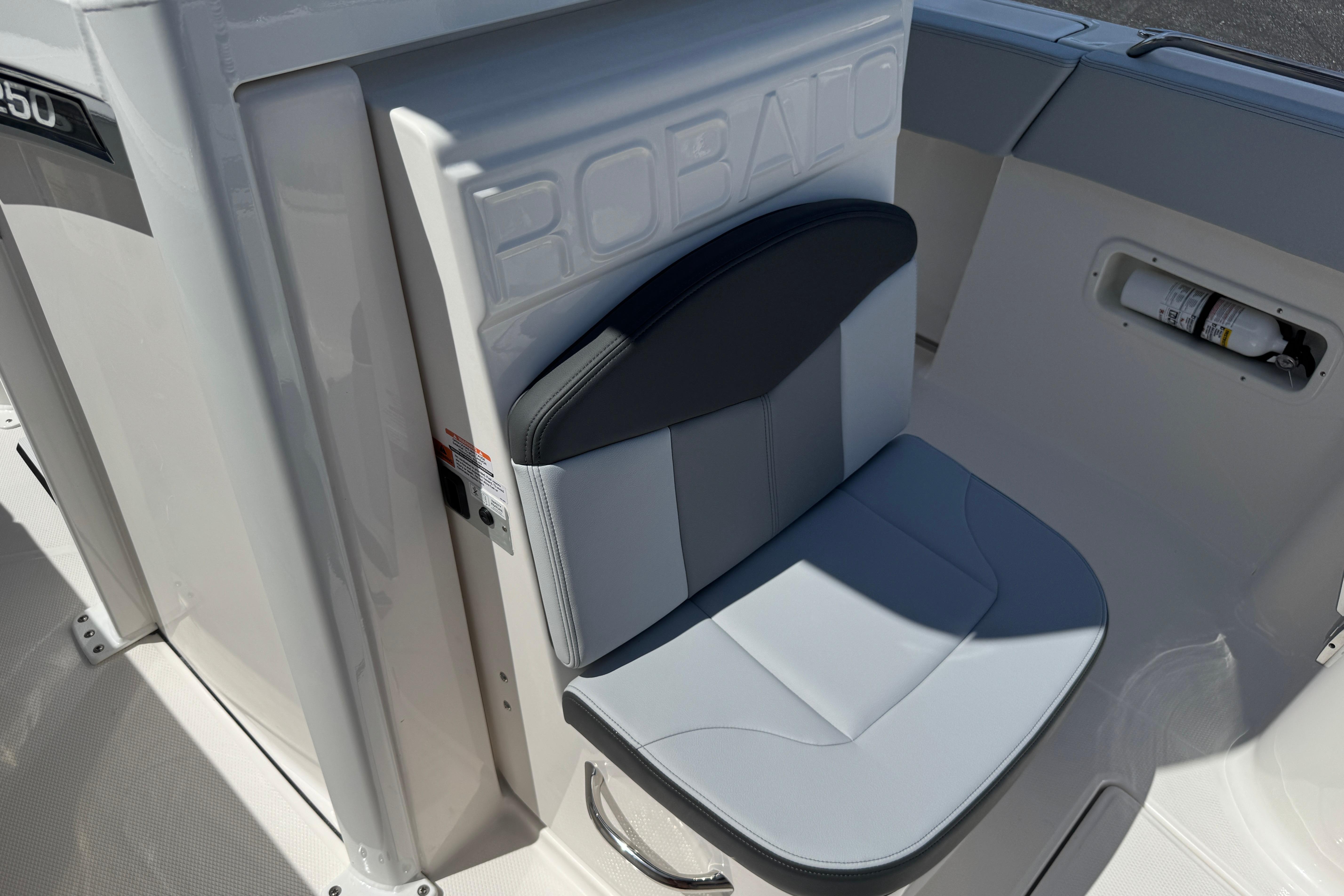 2026 Robalo R250 Center Console boat seat with integrated storage and fire extinguisher compartment.