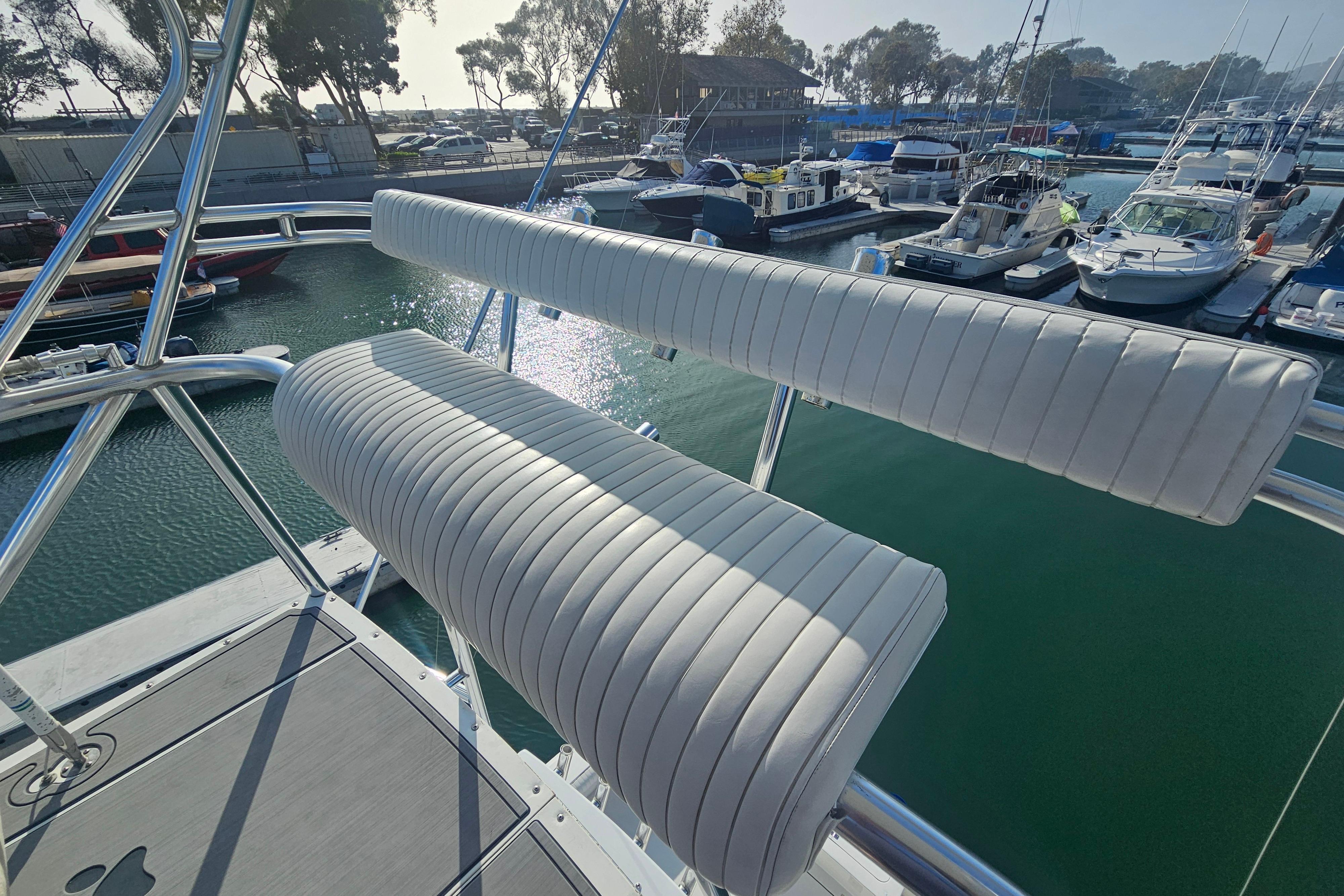2003 Topaz 32 Express boat with white cushioned seating at a marina.