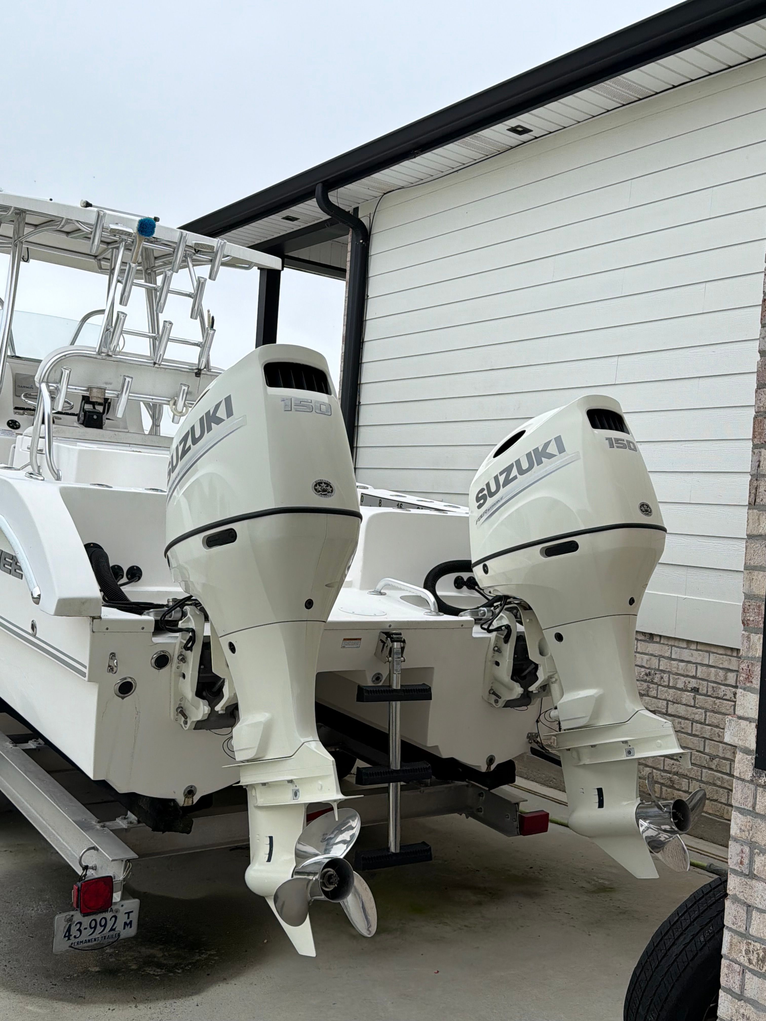 A Twin Vee Ocean Cat boat with two Suzuki outboard motors on a trailer.