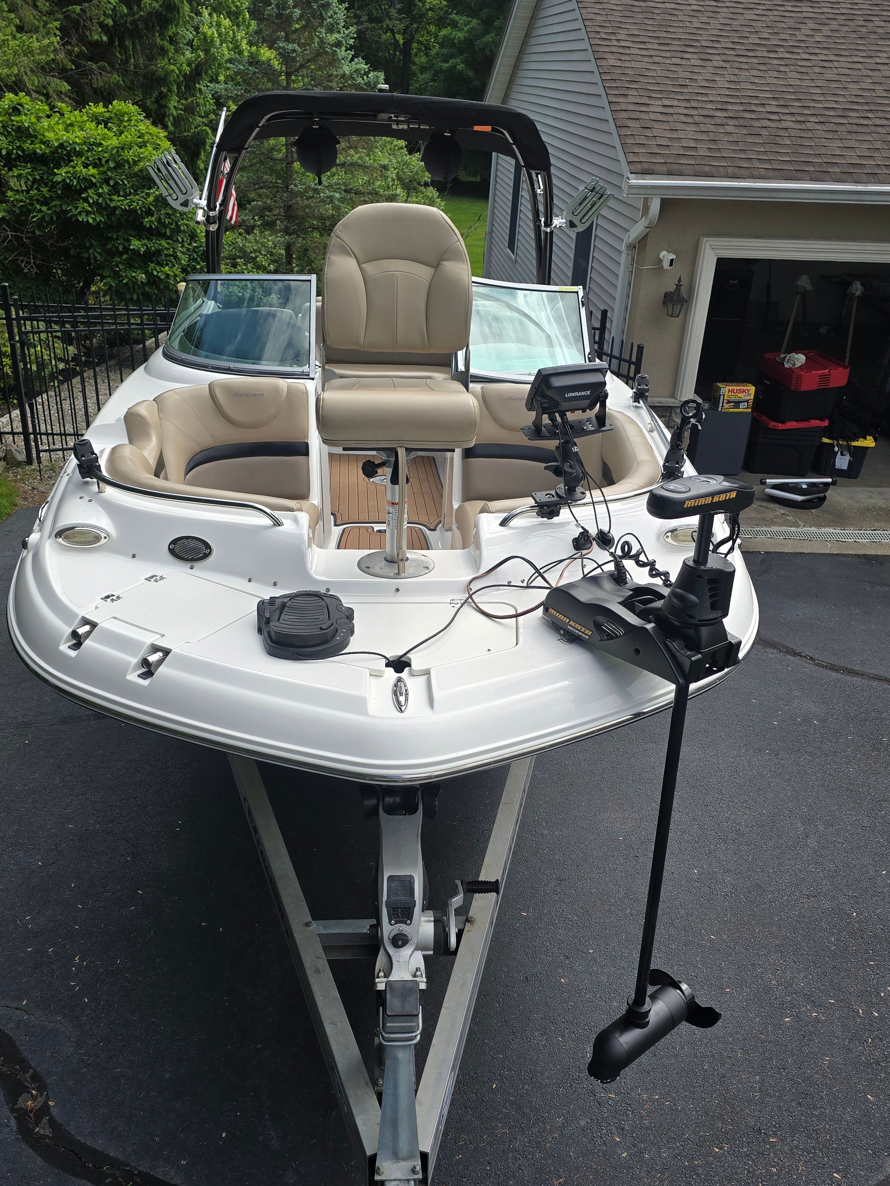 2016 Hurricane SD 2200 boat on a trailer in front of a garage.