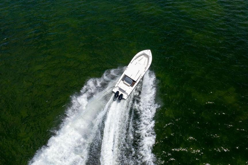 Aerial view of 2027 Reef Runner 340 boat cruising on green water.