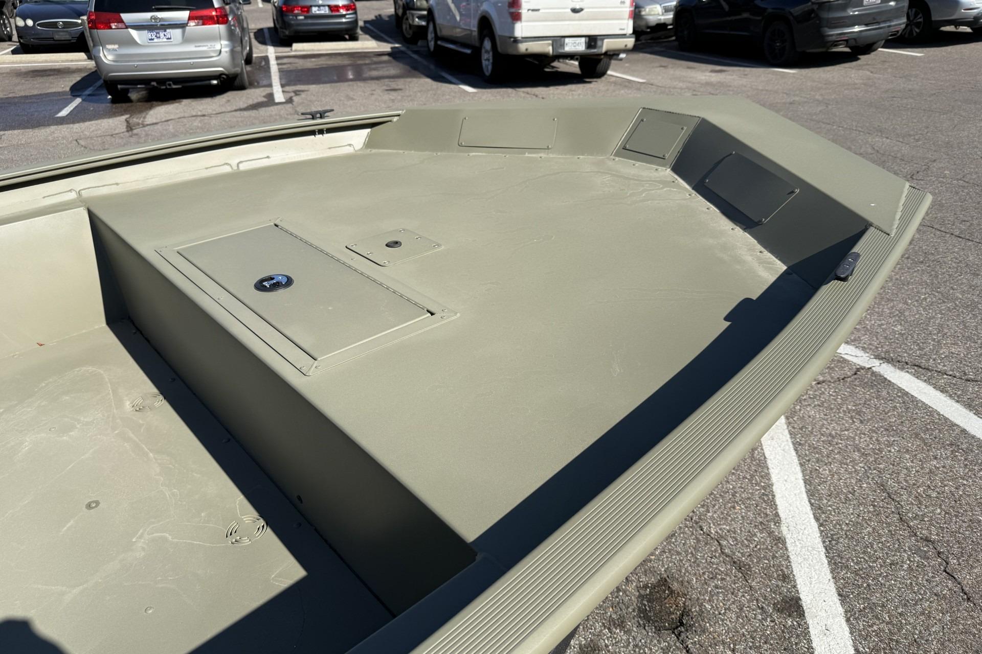 2026 Tracker Grizzly 1860 Utility boat in a parking lot, showcasing its spacious deck.