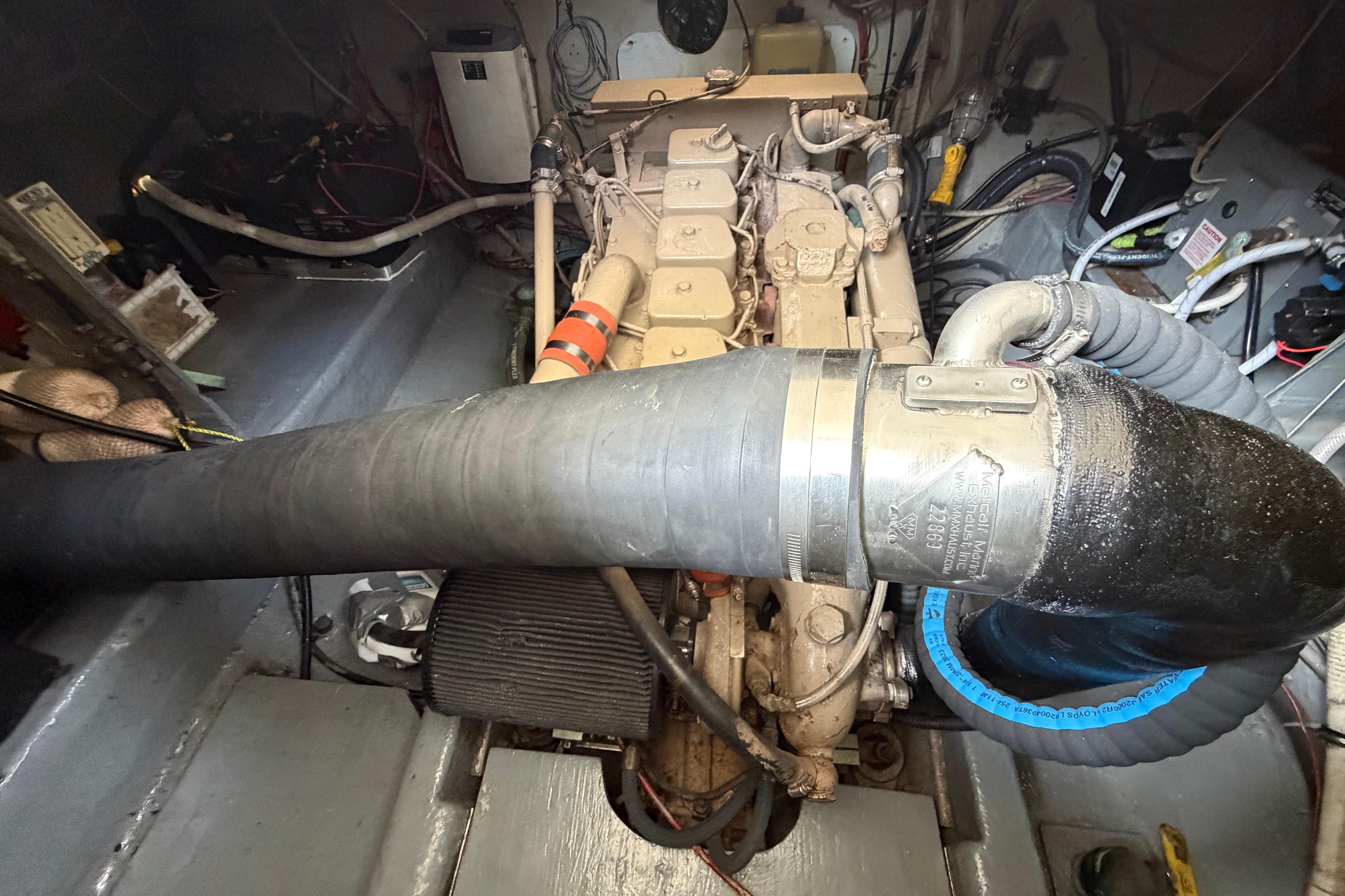 Engine compartment of a 1986 Albin 34 Family Cruiser, showcasing mechanical components and hoses.