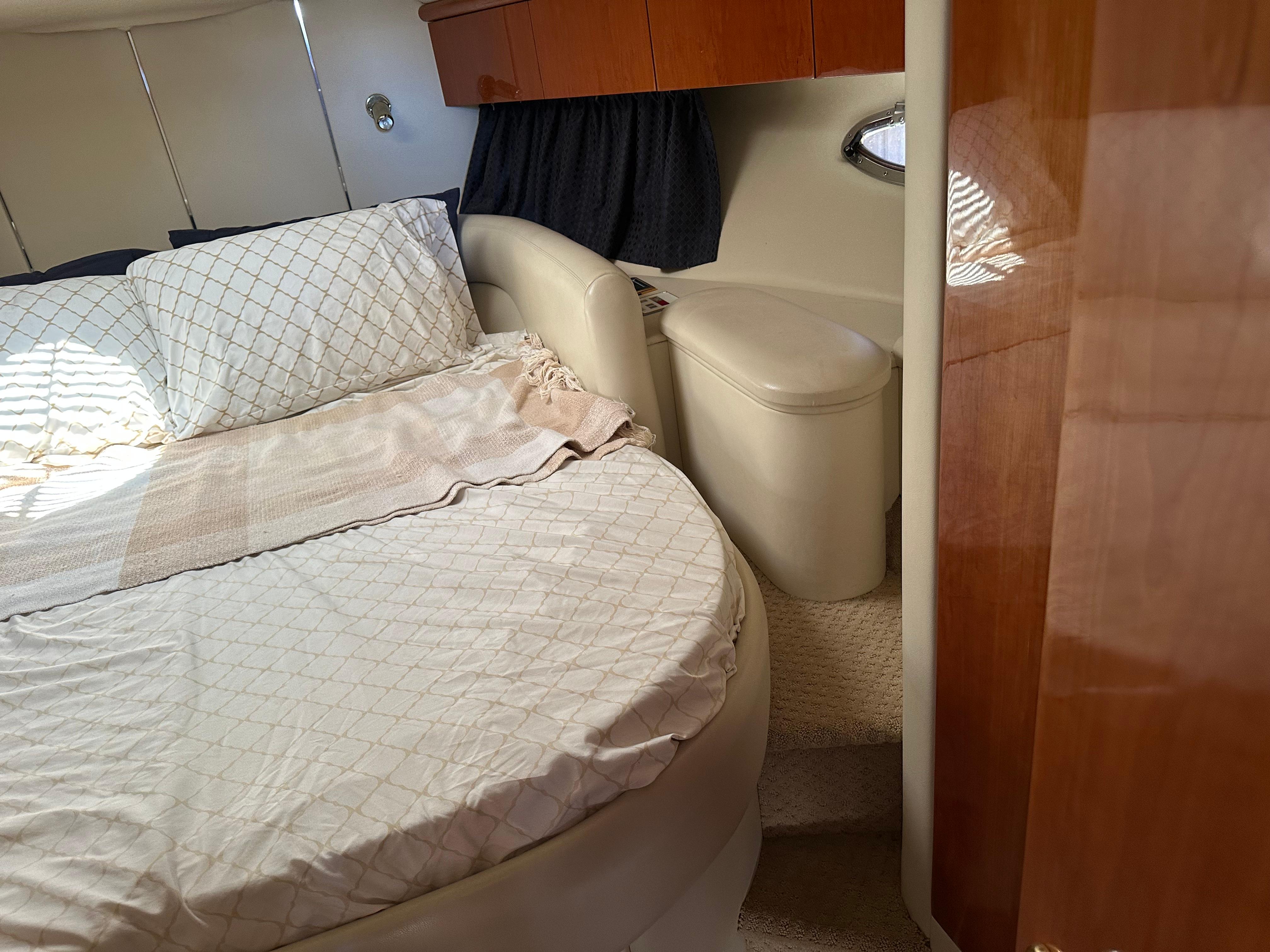 Interior cabin of 1997 Sunseeker Camargue 47 yacht with bed and wooden cabinetry.
