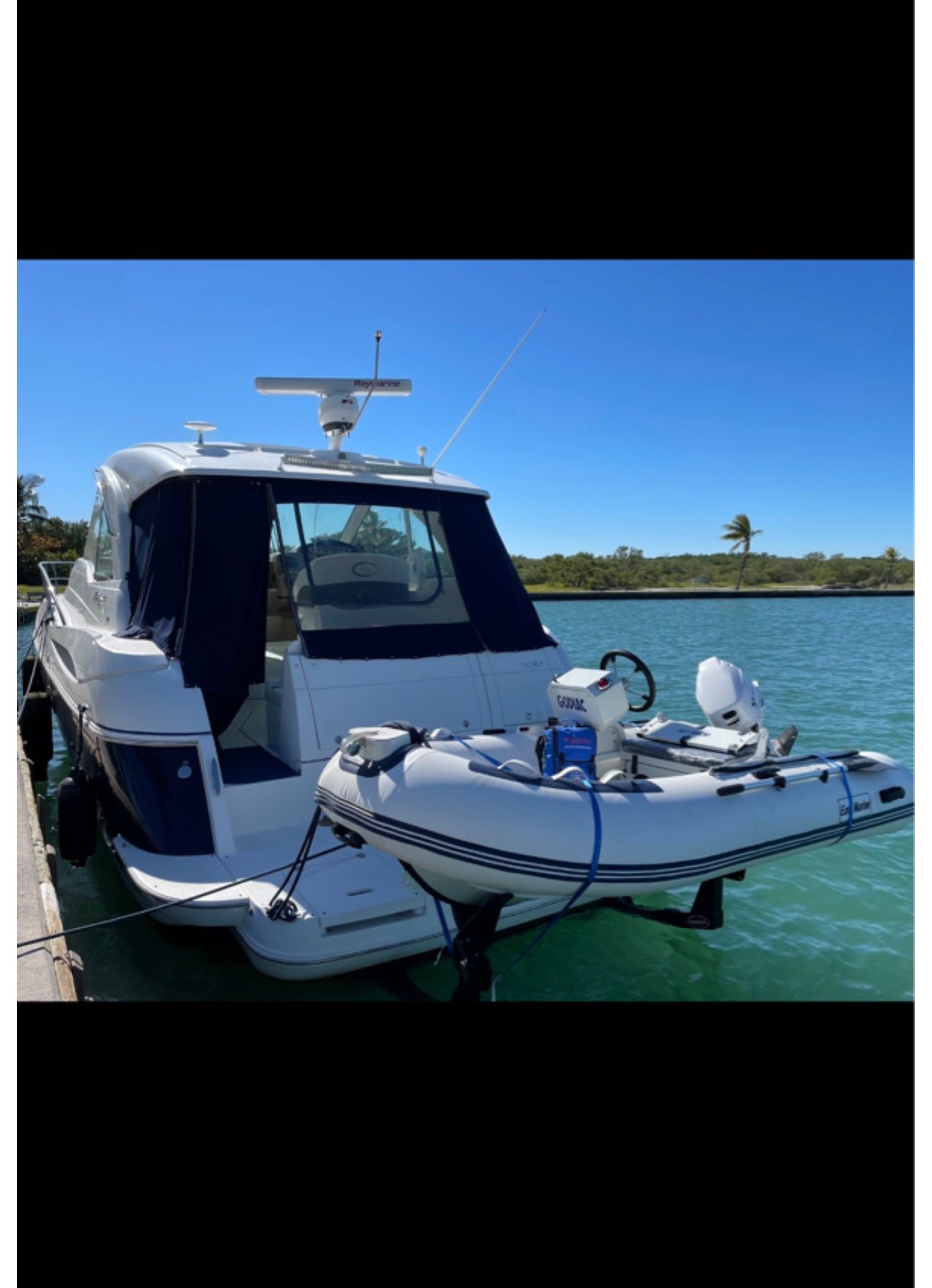2012 Cruisers Yachts 430 Sports Coupe docked with dinghy.