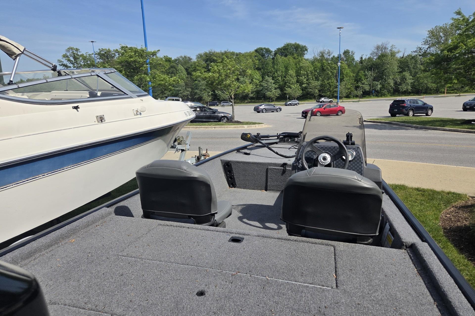 2024 TRACKER MARINE CLASSIC XL boat interior with steering wheel and seats in a parking lot.
