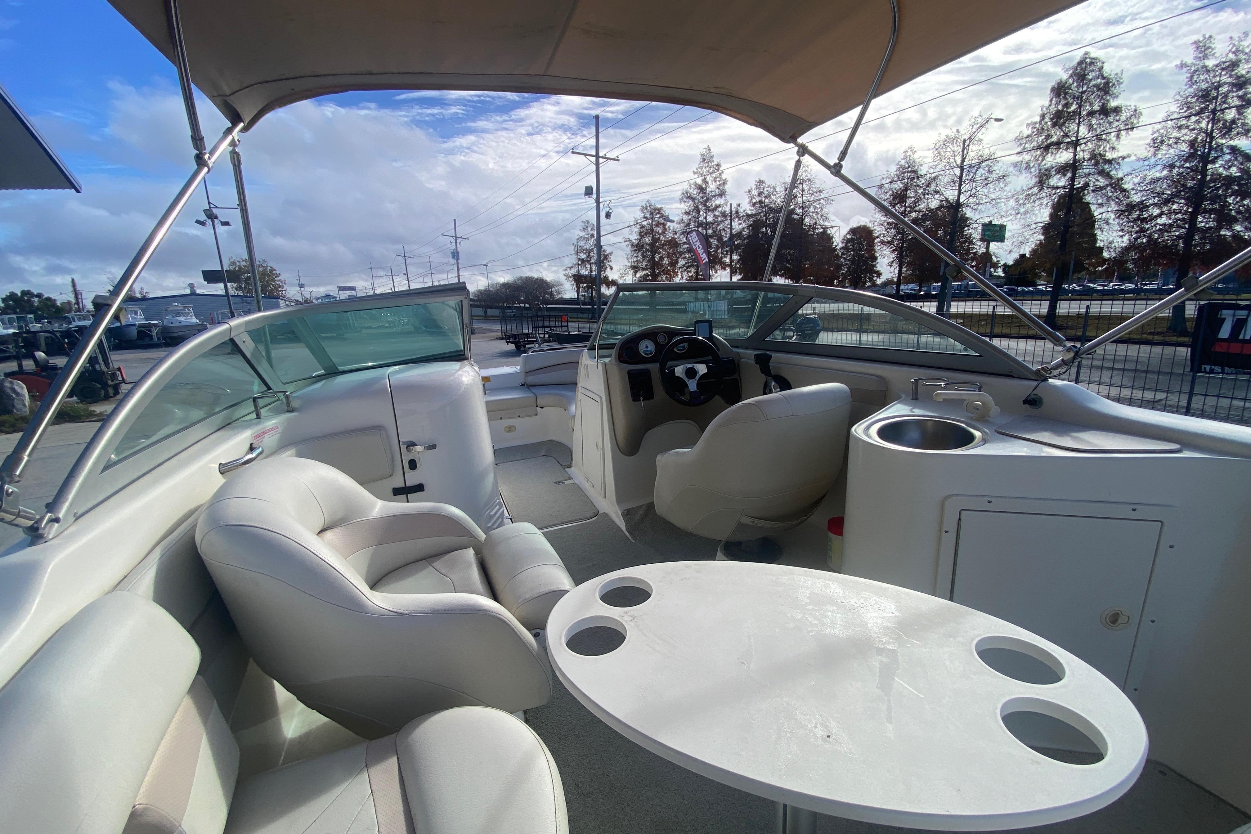2007 NauticStar 230DC Sport Deck boat interior with seating, table, and helm.