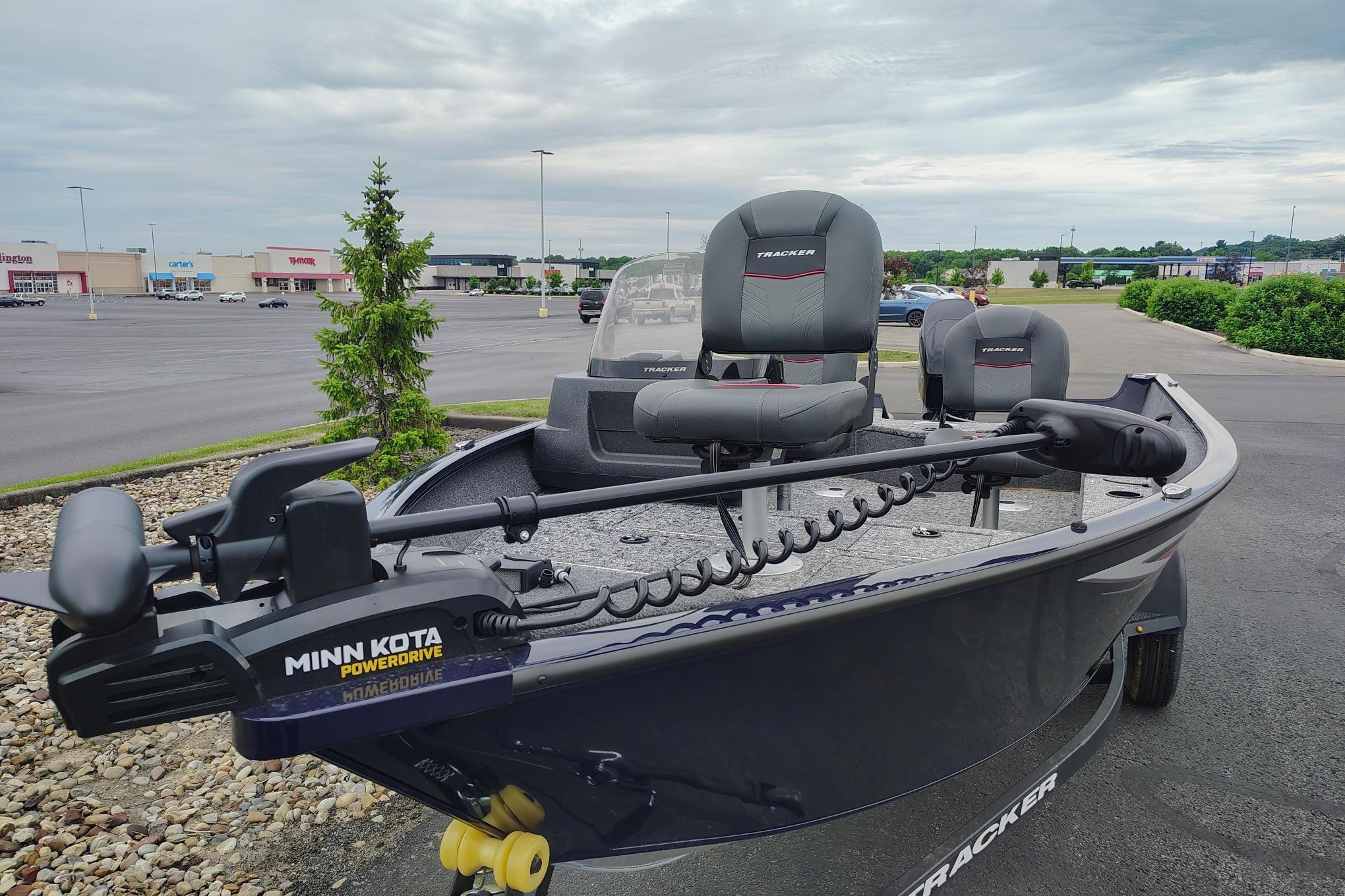 2026 Tracker Pro Guide V-16 SC boat with Minn Kota PowerDrive motor in parking lot.