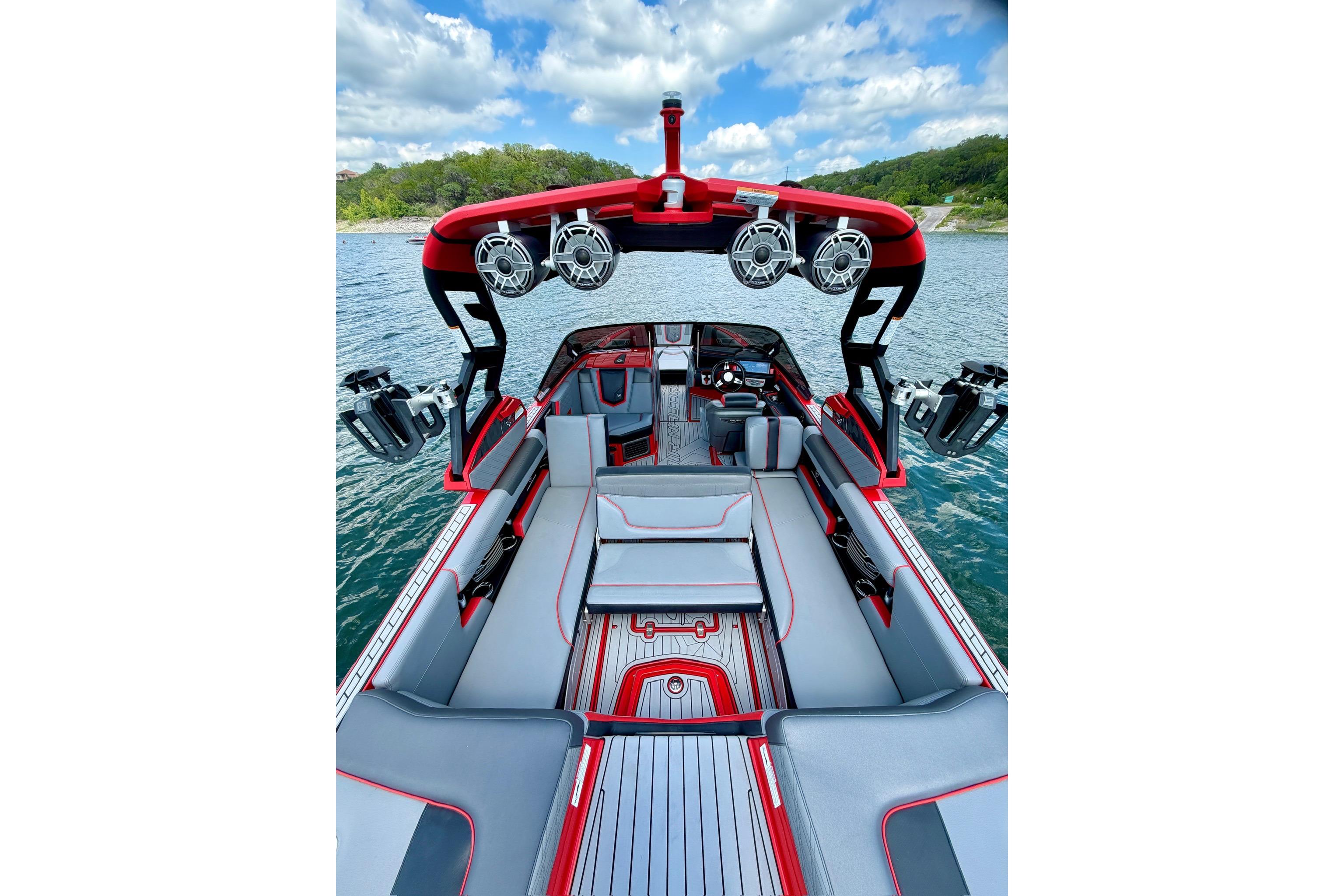 2019 Nautique Super Air Nautique G25 boat interior with red and gray seating on a lake.