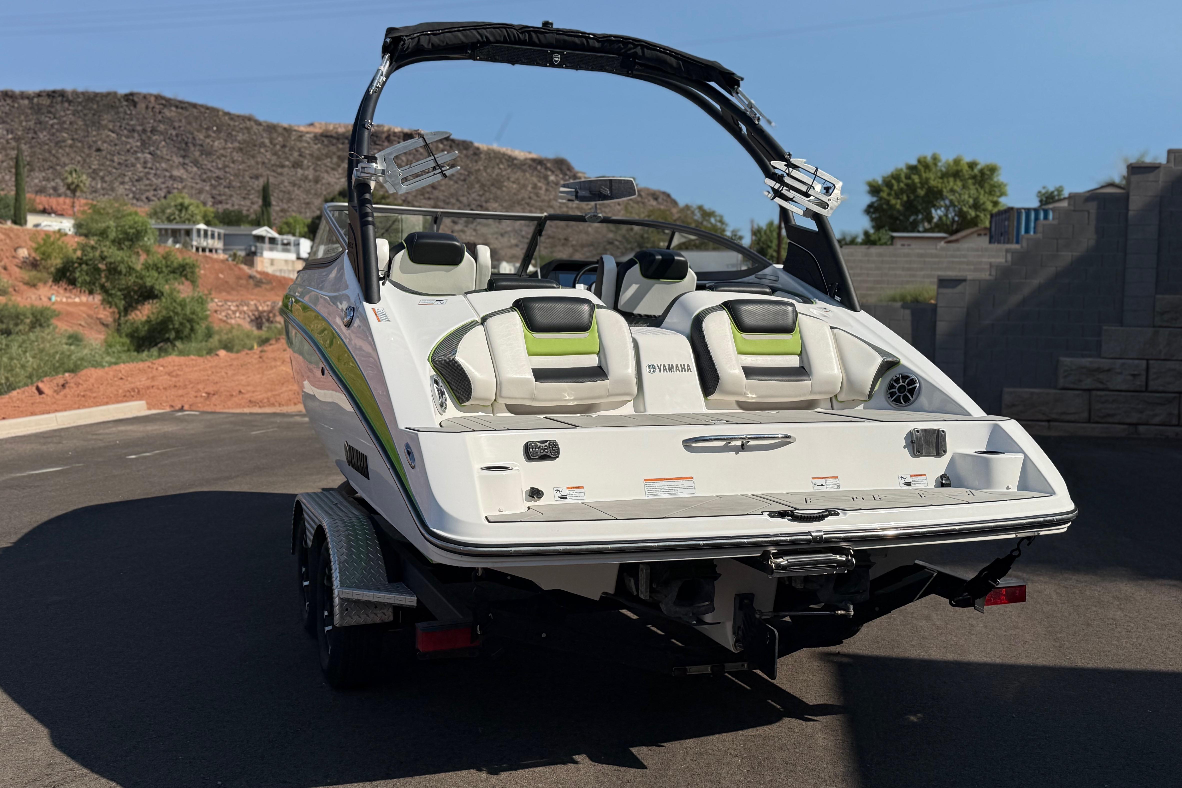 2022 Yamaha Boats 212XE on trailer, rear view, outdoors with scenic background.
