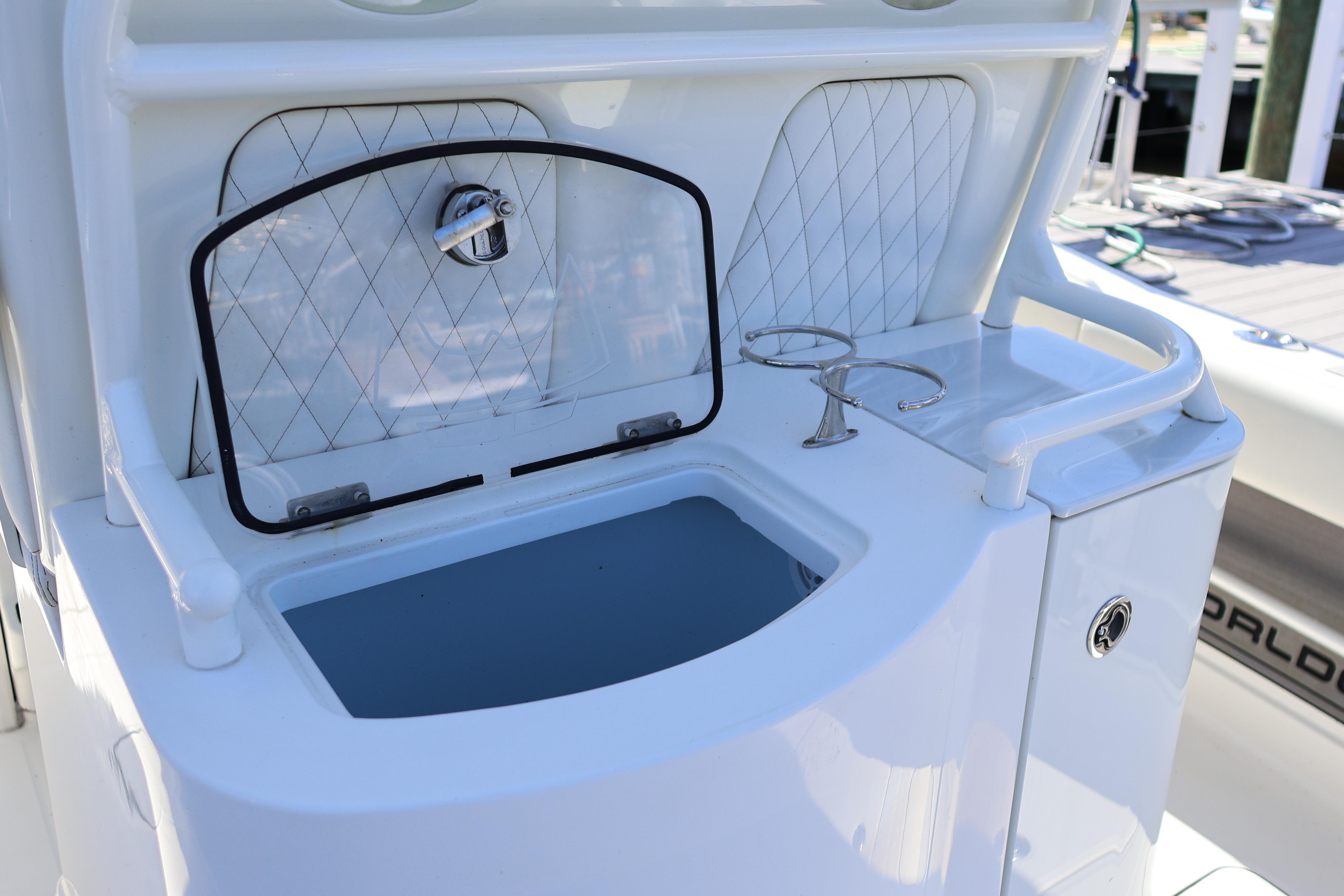2022 World Cat 280 CC-X boat with open storage compartment and cup holders.