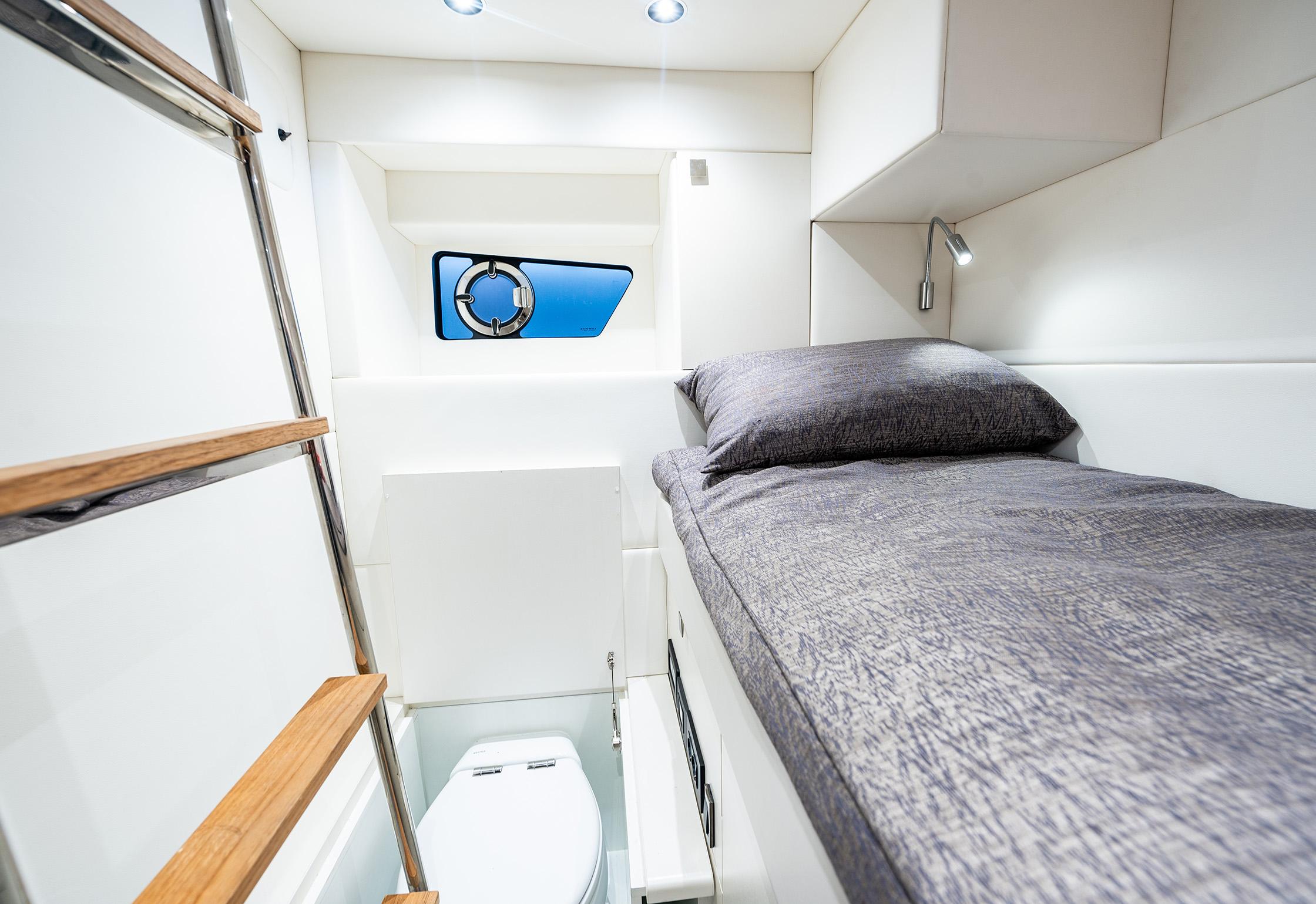 2023 Sunseeker Predator 65 cabin interior with bed, window, and compact bathroom.