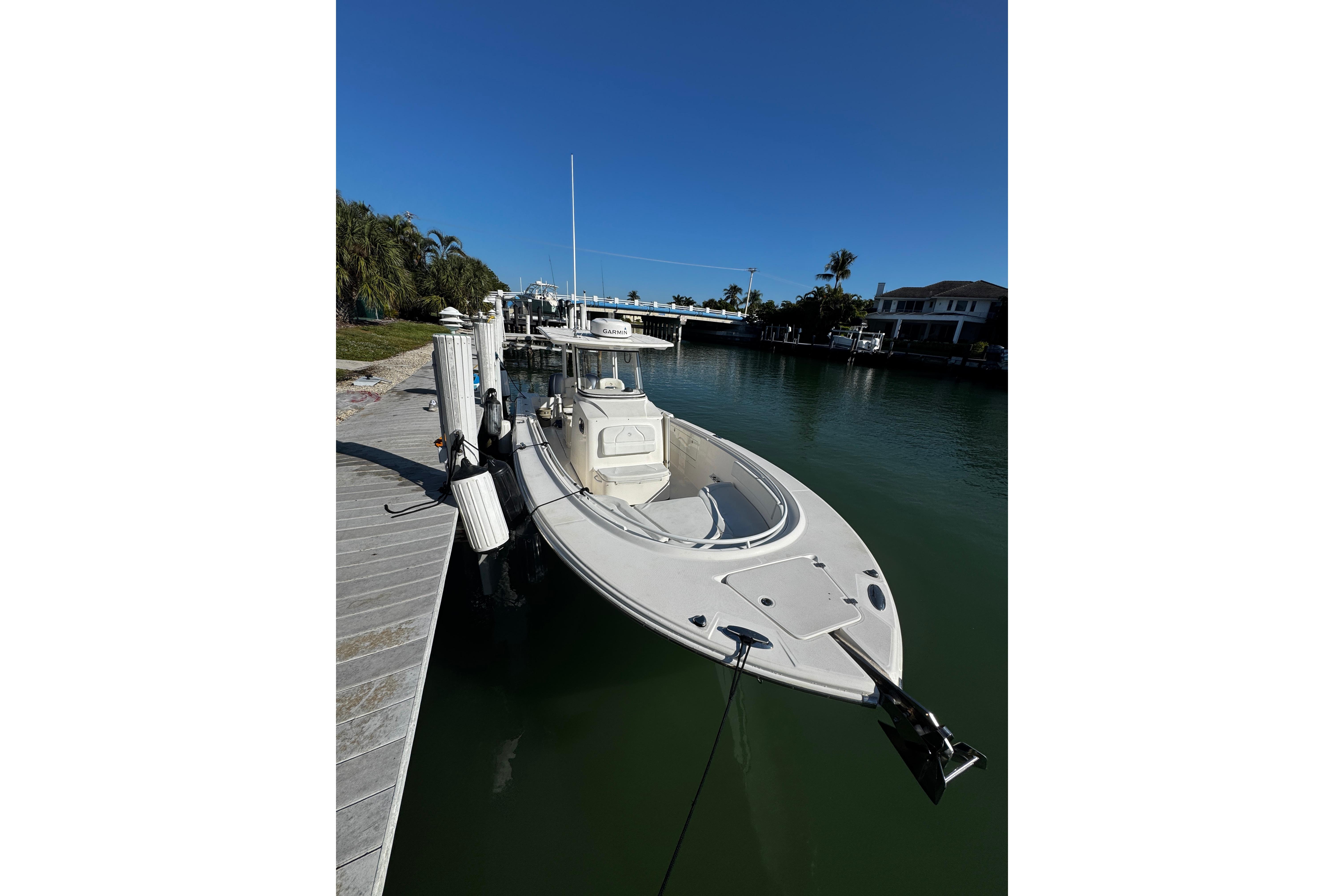2015 Edgewater 320CC boat docked in a serene waterfront setting.