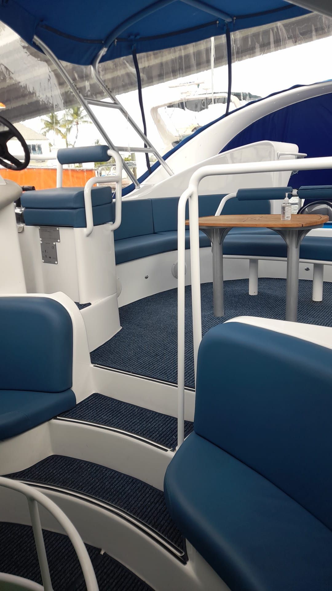 The interior of a modern boat with blue seating and a table.