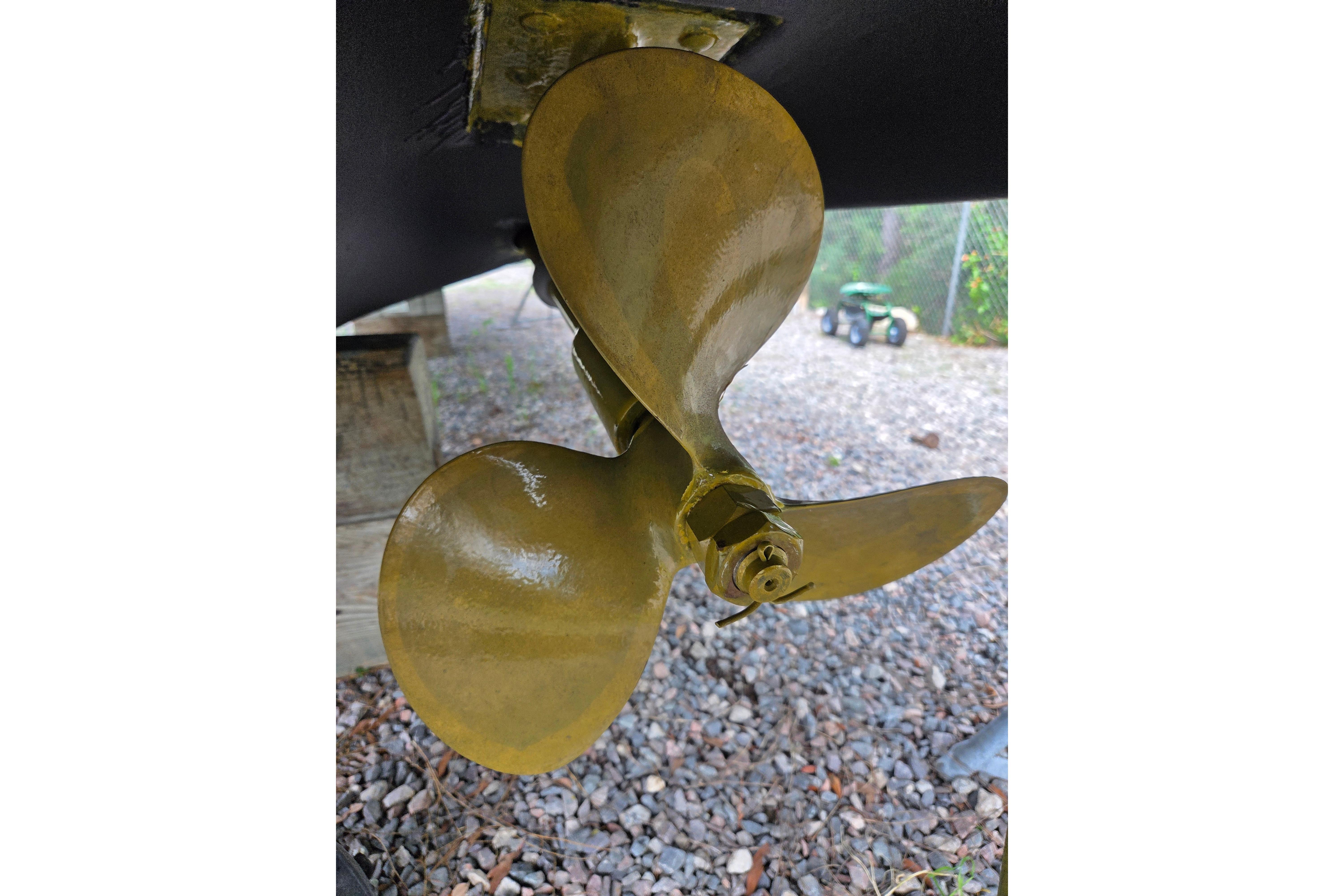 Propeller of a 2000 Sea Ray 340 Sundancer boat on gravel surface.