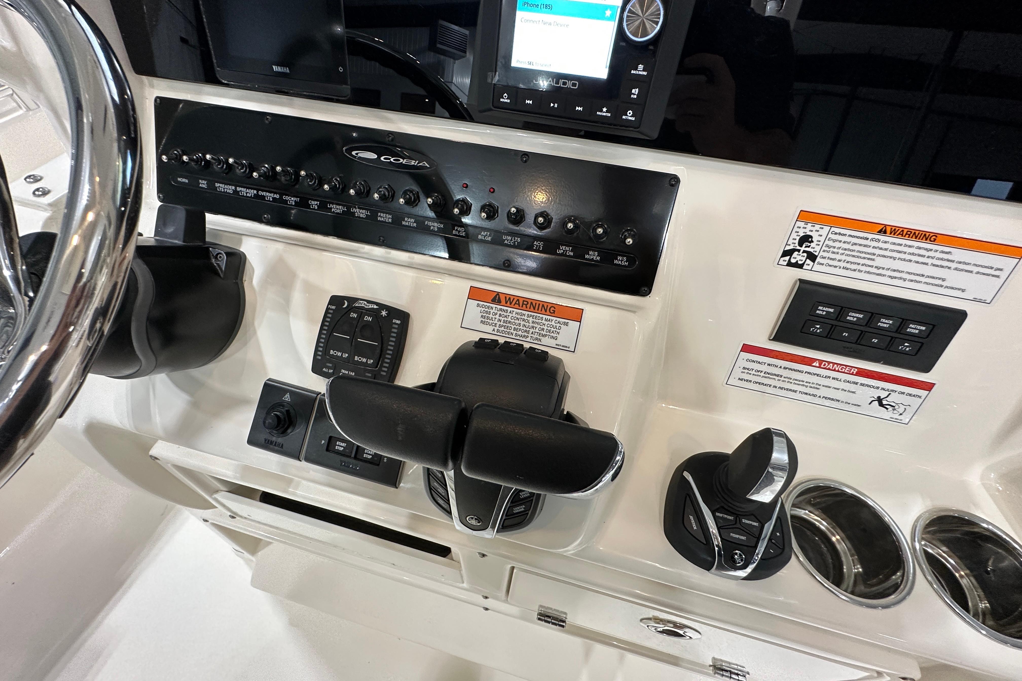 2024 Cobia 301 Center Console dashboard with controls and warning labels.