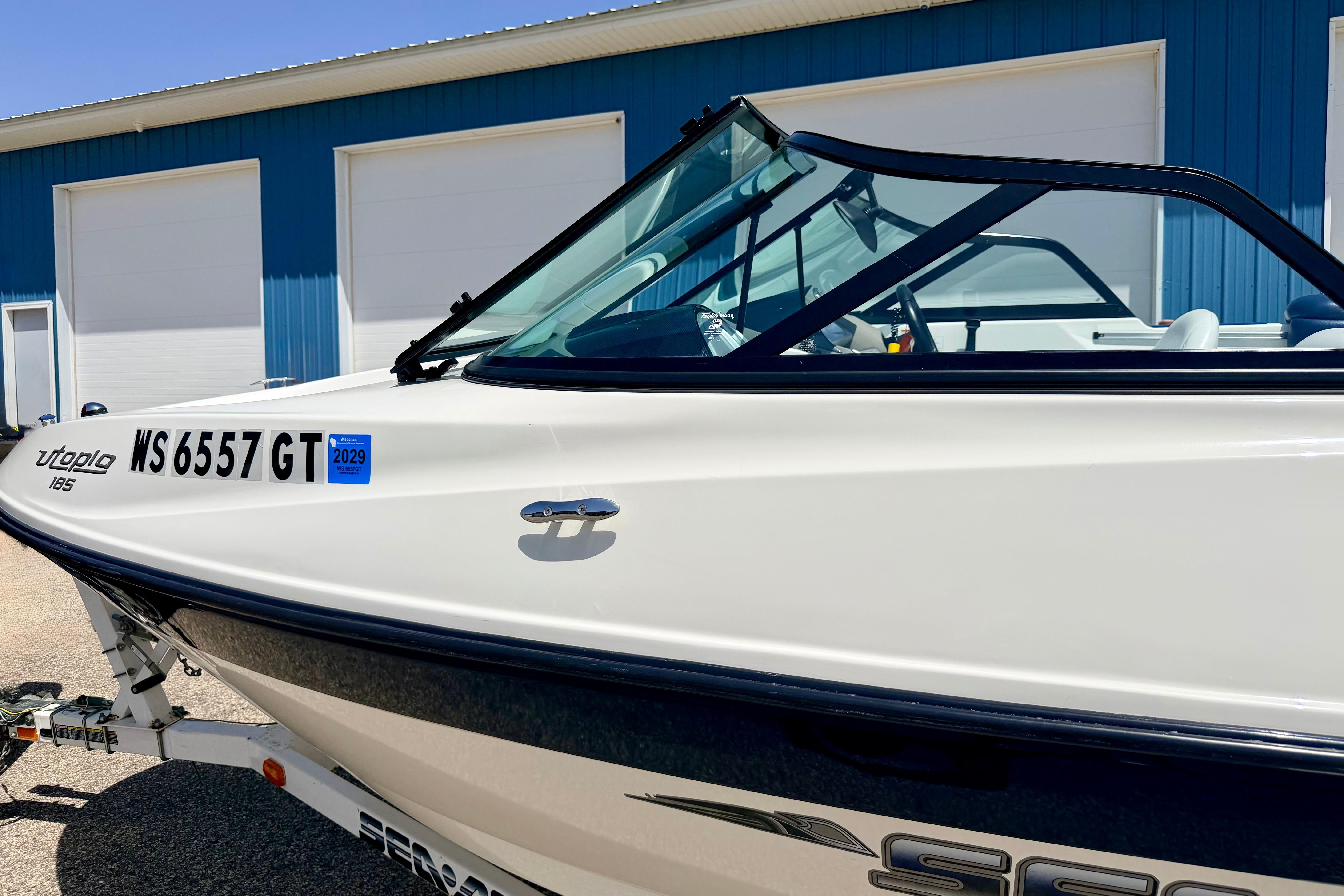 2004 Bombardier SEADOO Utopia 185 boat parked near blue building.