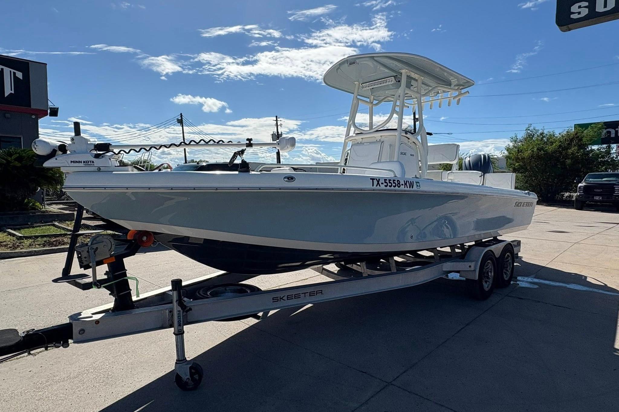 2023 Skeeter SX2550 Family boat on trailer under clear blue sky.