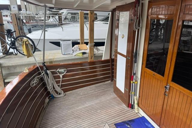 1986 Kadey-Krogen 42 boat deck with wooden finish and docked marina view.