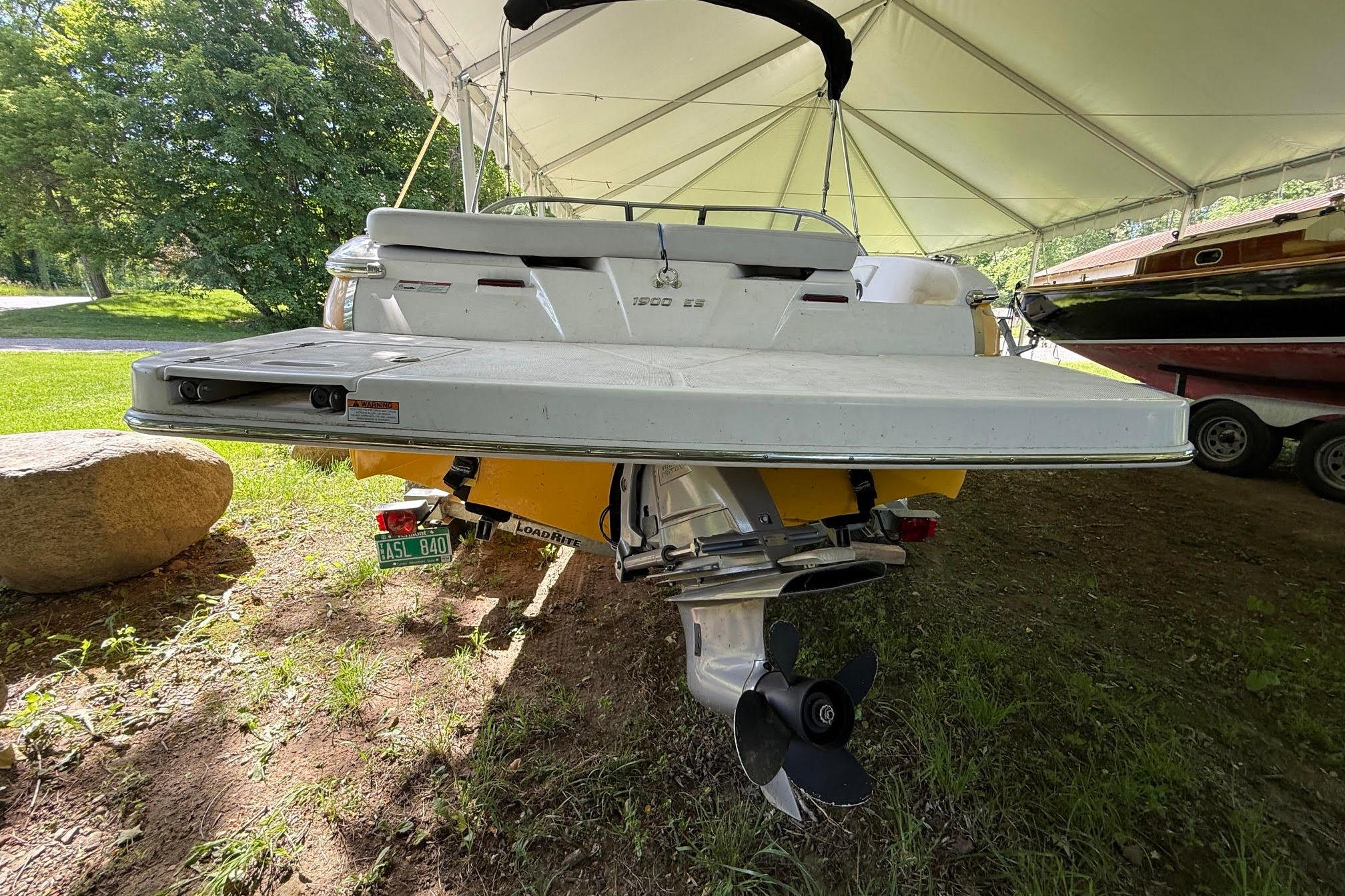 2016 Regal 1900 ES Bowrider under canopy, rear view with propeller visible.