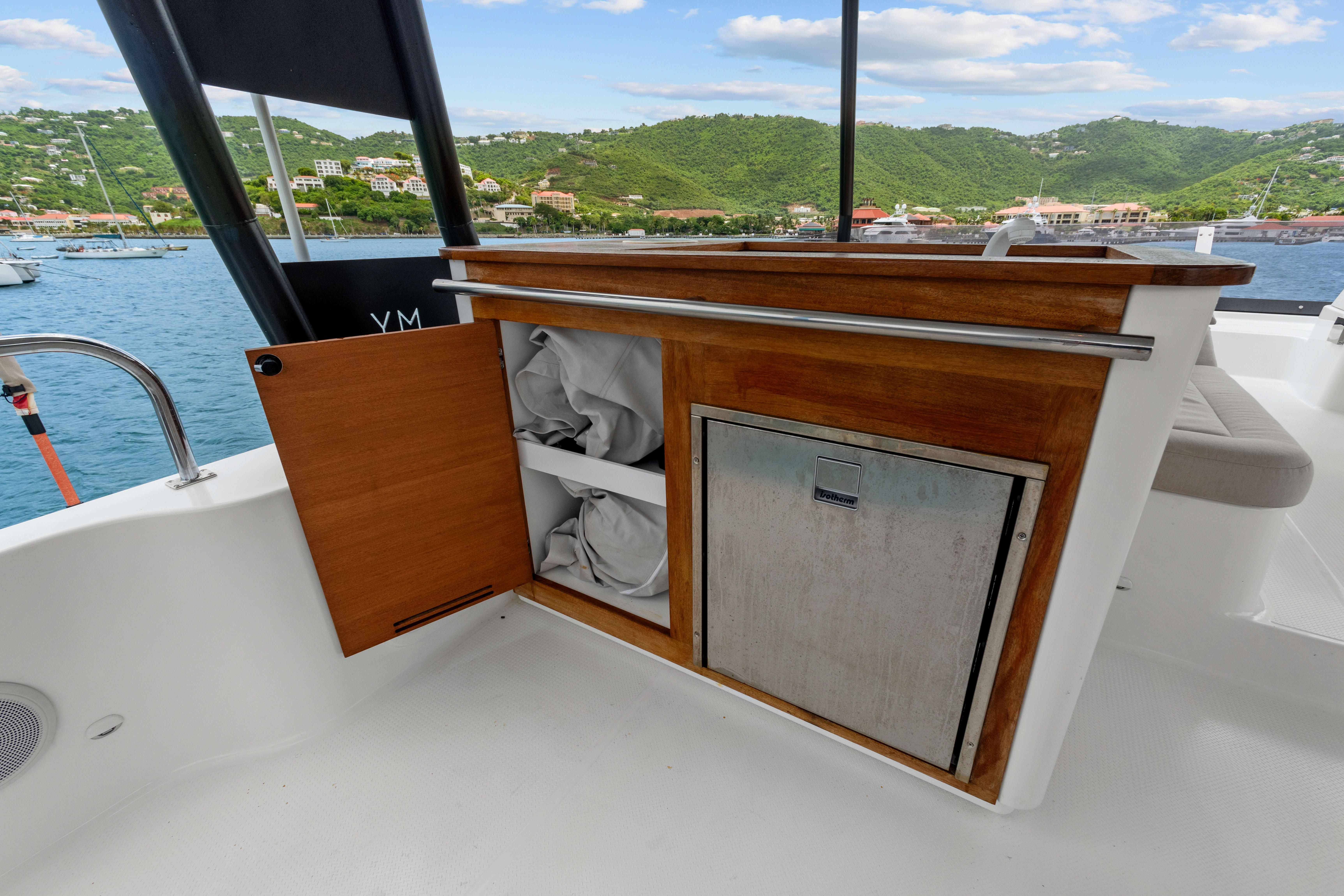 2024 Fountaine Pajot MY6 yacht interior with wooden storage and scenic ocean view.