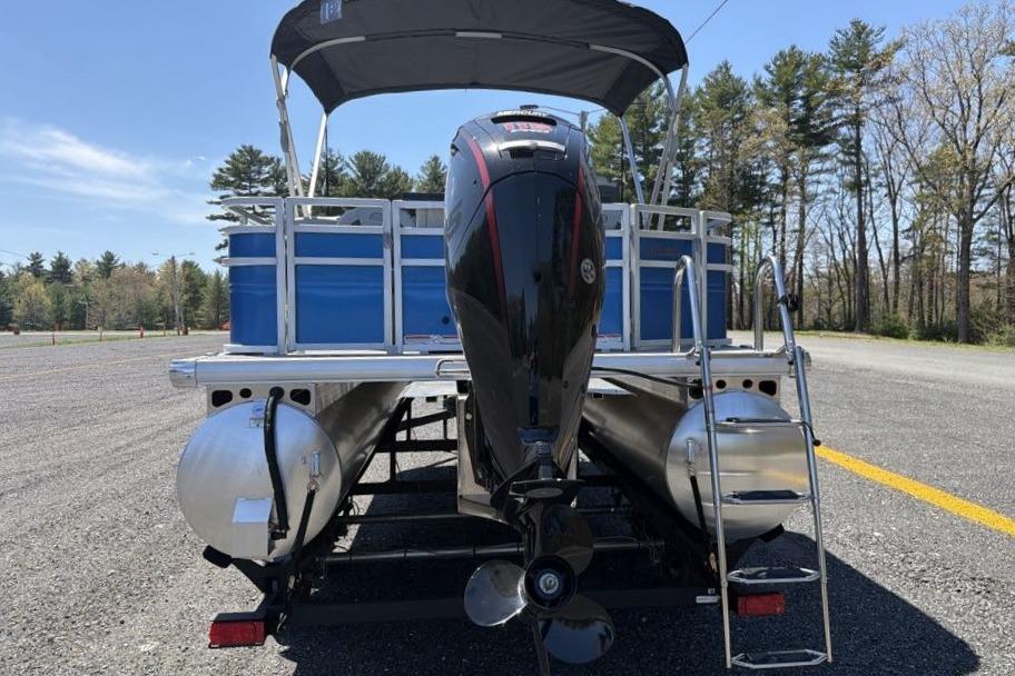 2026 Sun Tracker Fishin' Barge 20 DLX pontoon boat with outboard motor and canopy.