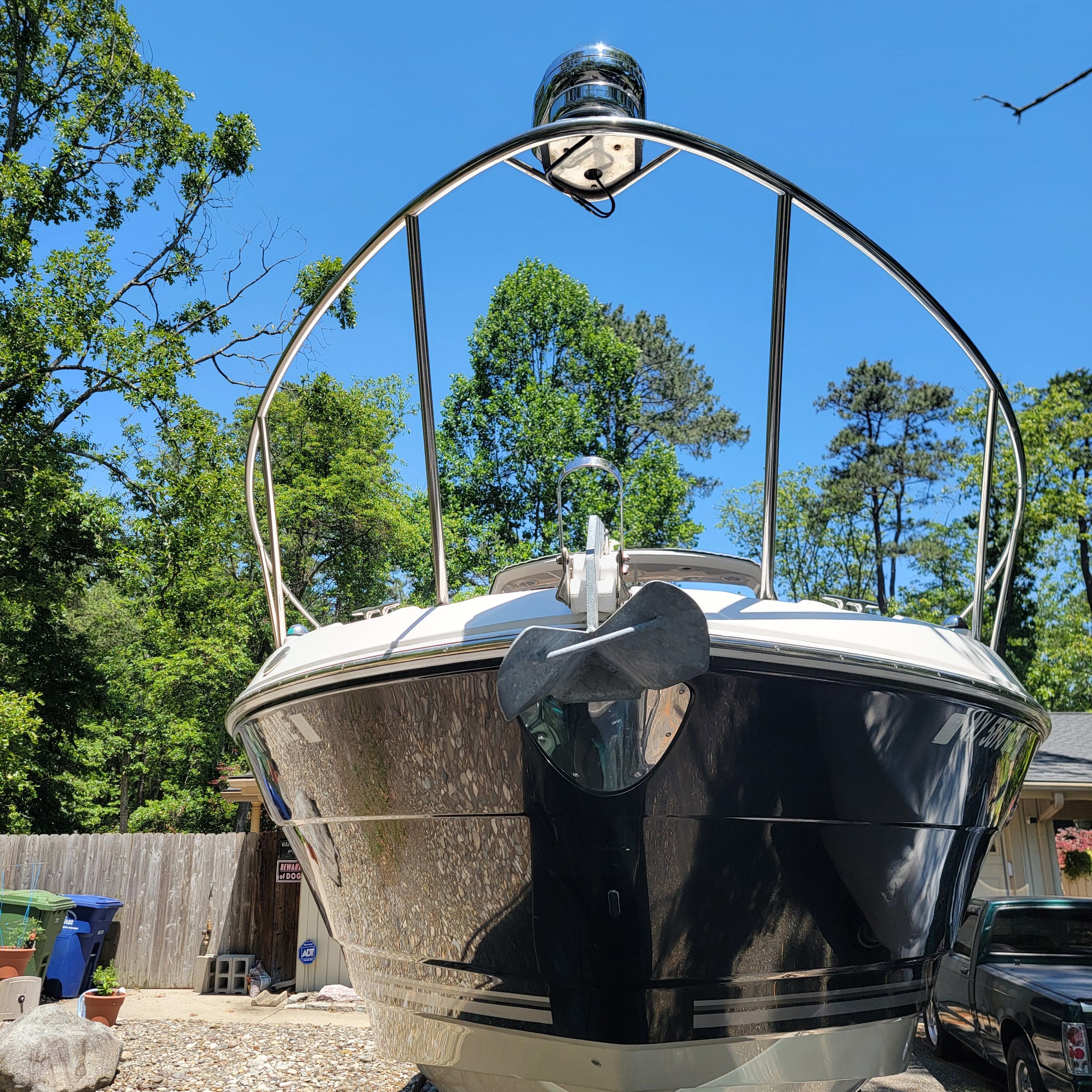 A Monterey 290 Cruiser boat is on a dry dock, surrounded by trees.