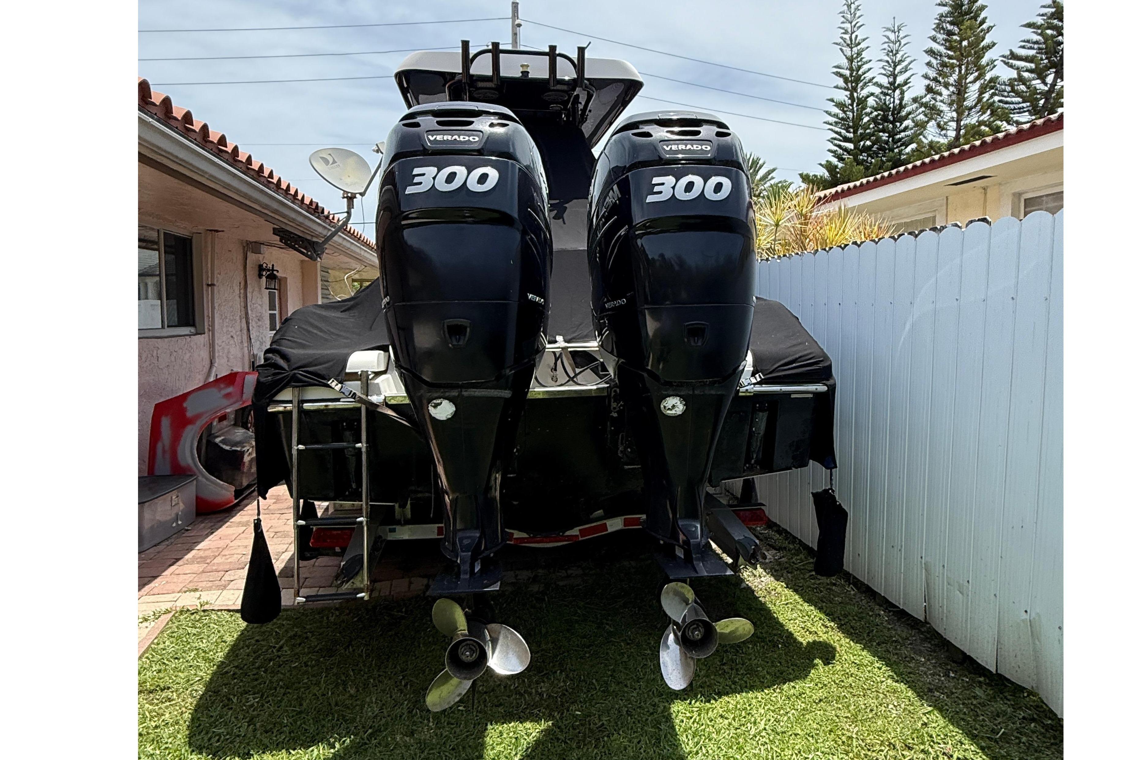 2015 Blackwood 27 boat with twin 300 horsepower engines, parked on grass.