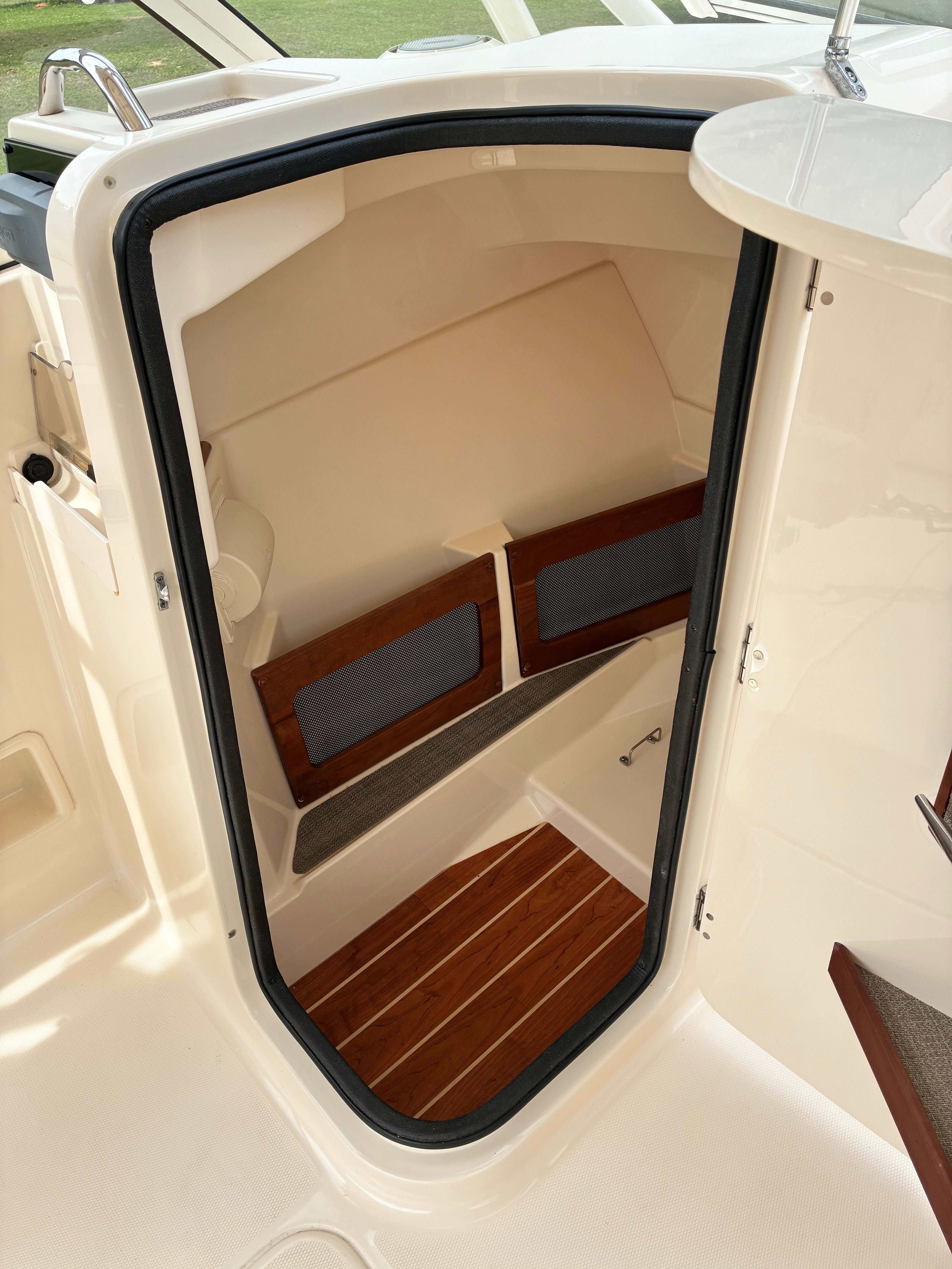 Interior of 2018 Grady-White Freedom 235 with wooden flooring.