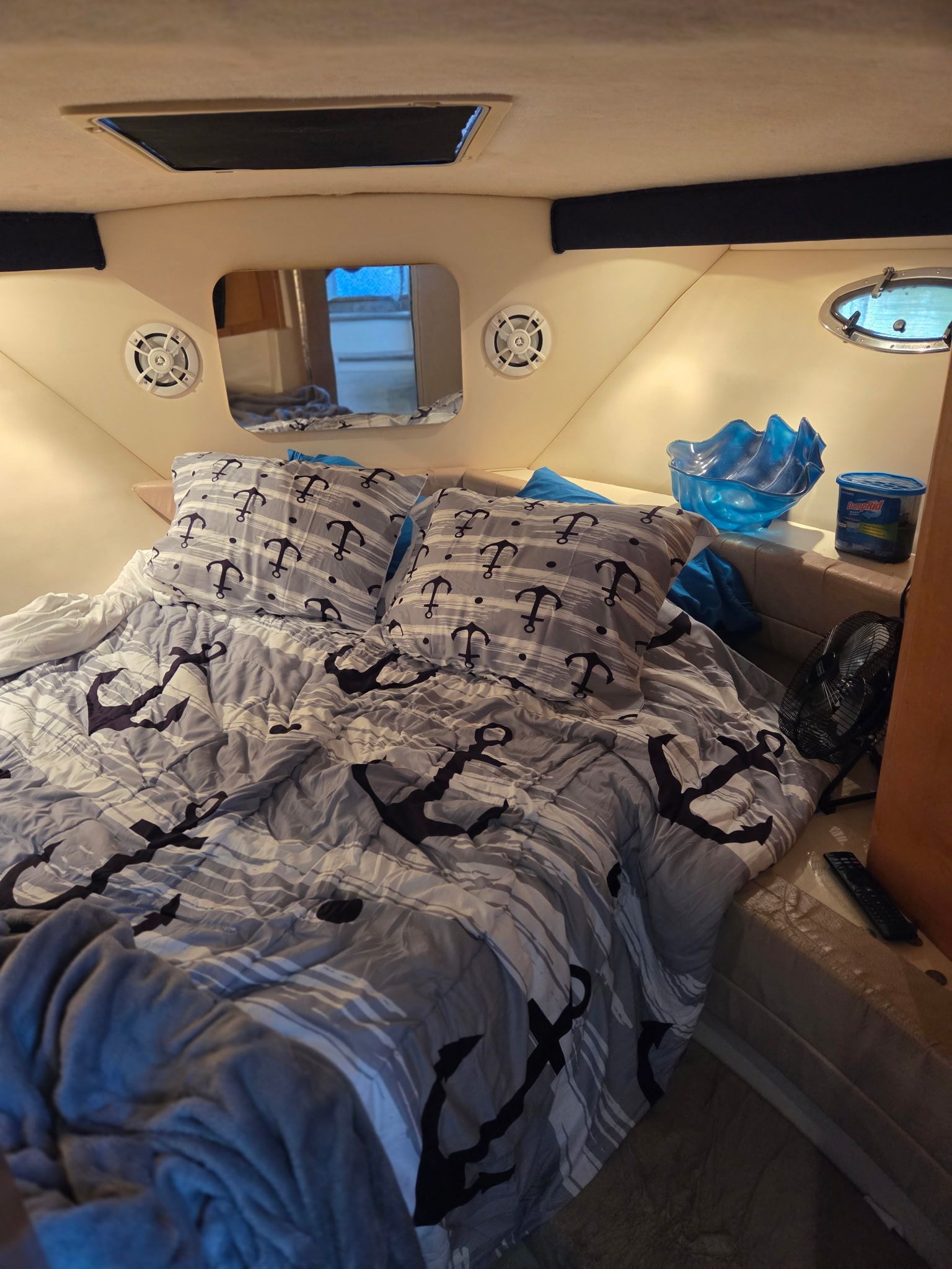 Interior of a 1996 Carver Voyager with a cozy bed and nautical-themed bedding.