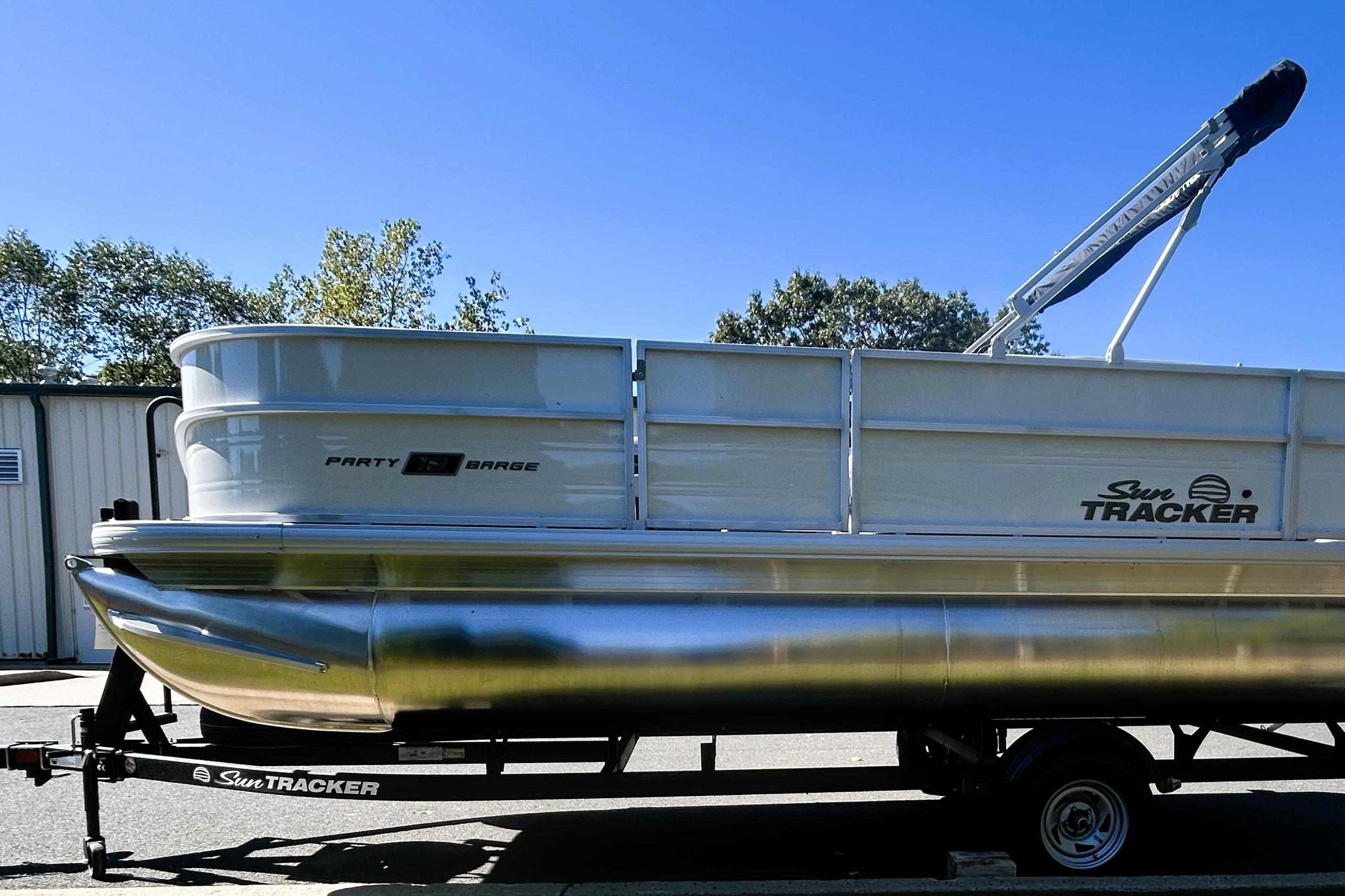 2026 Sun Tracker Party Barge 18 DLX pontoon boat on trailer, outdoors.