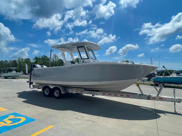 2023 Robalo R270 boat on a trailer under a blue sky.