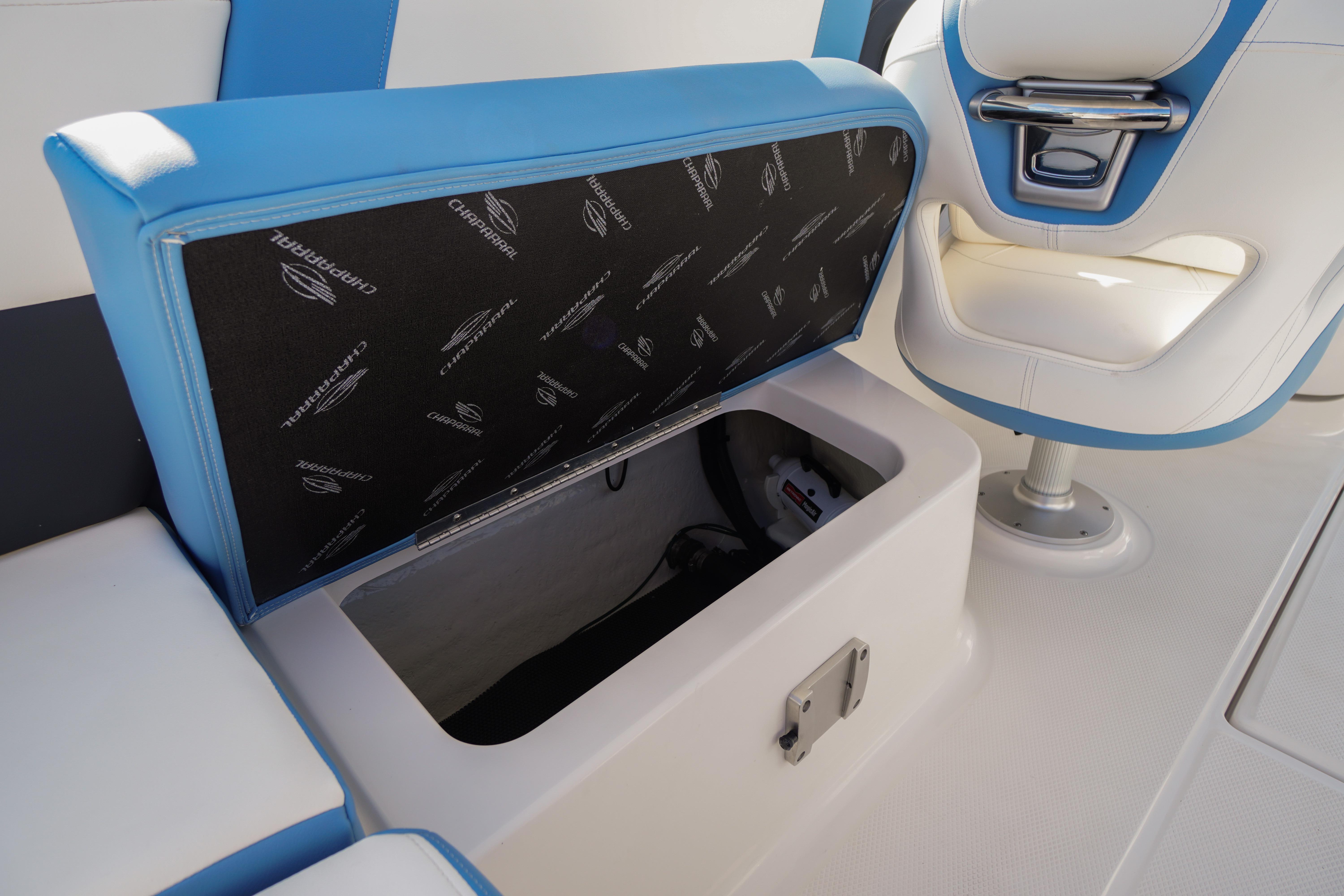 2026 Chaparral 270 OSX boat interior with open storage compartment and blue-white seating.