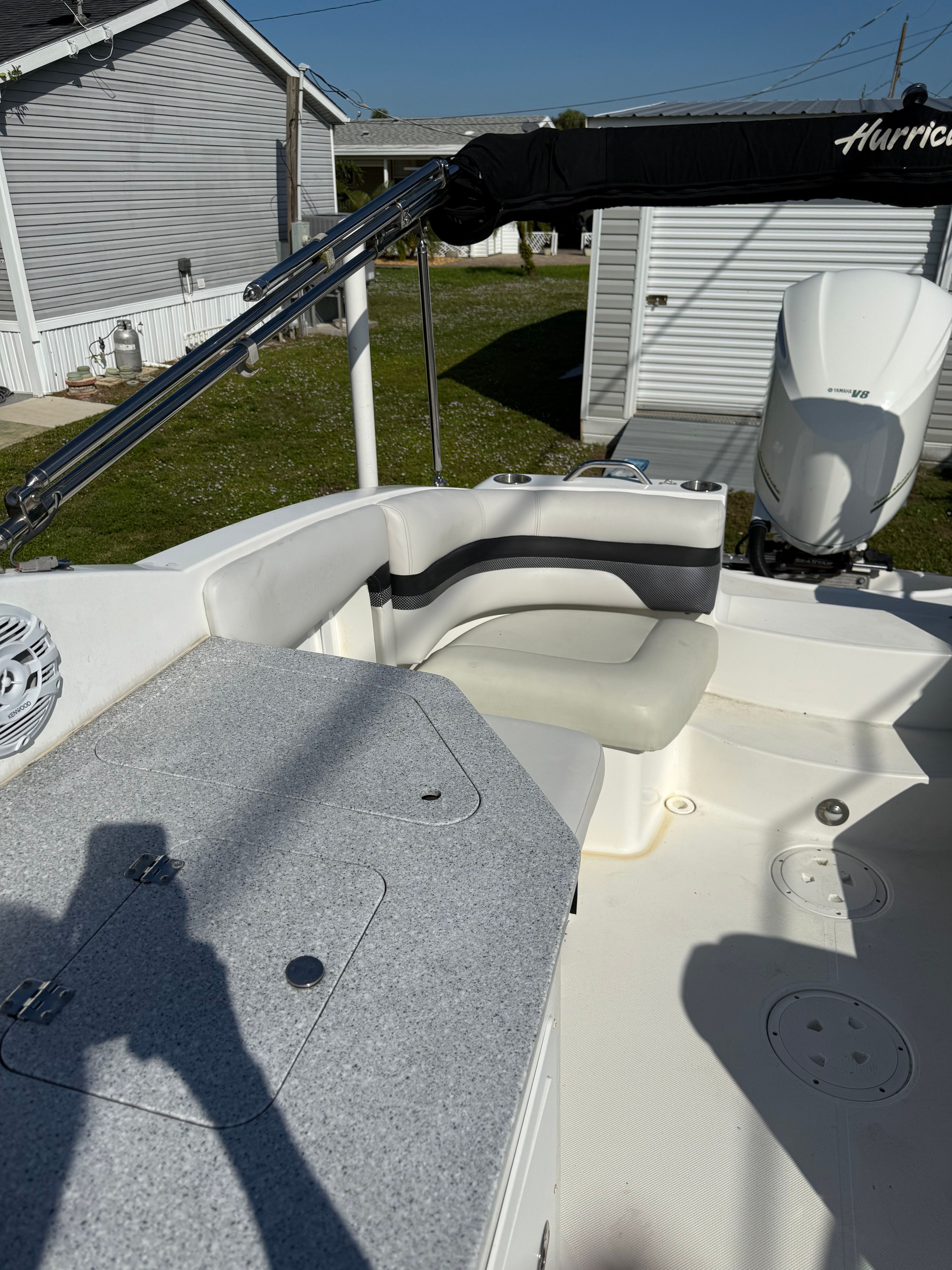 2018 Hurricane SunDeck 2690 OB boat with seating area and motor.