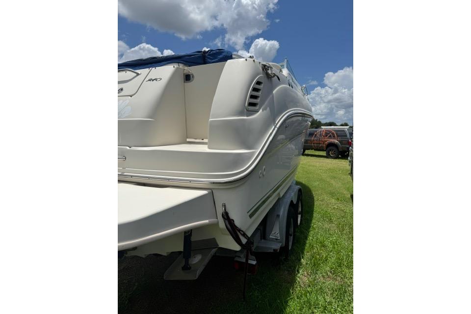 2004 Sea Ray 240 Sundancer boat on trailer under a cloudy sky.